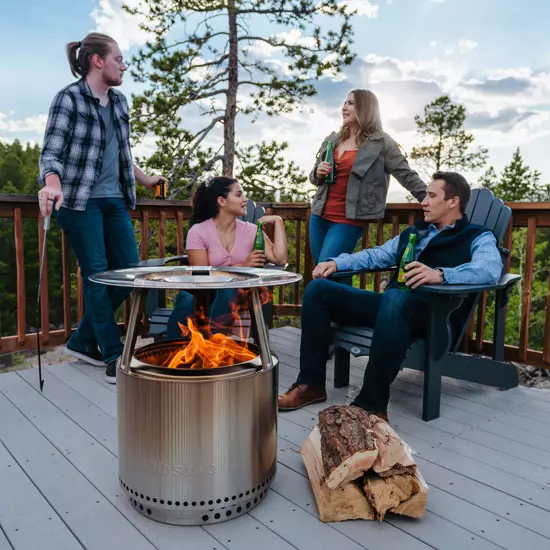 people sitting around a Solo Stove with heat deflector