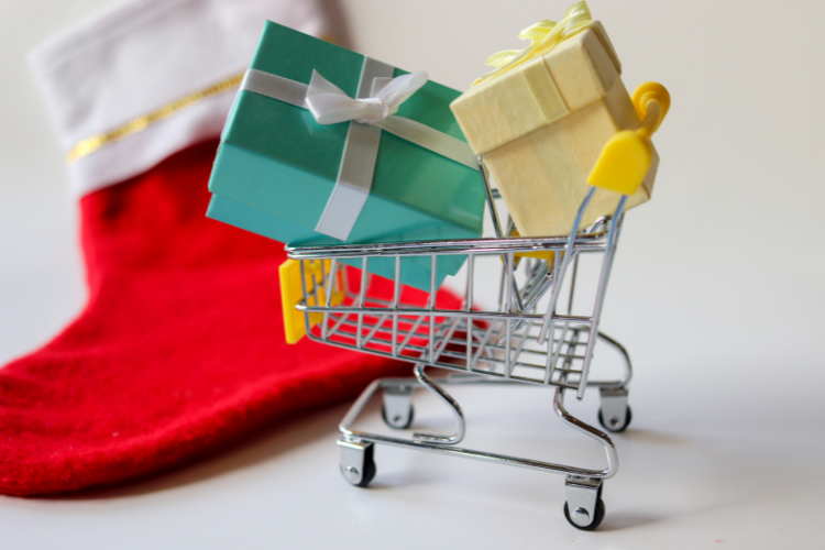 Shopping cart with retail gifts for sale next to a holiday season stocking