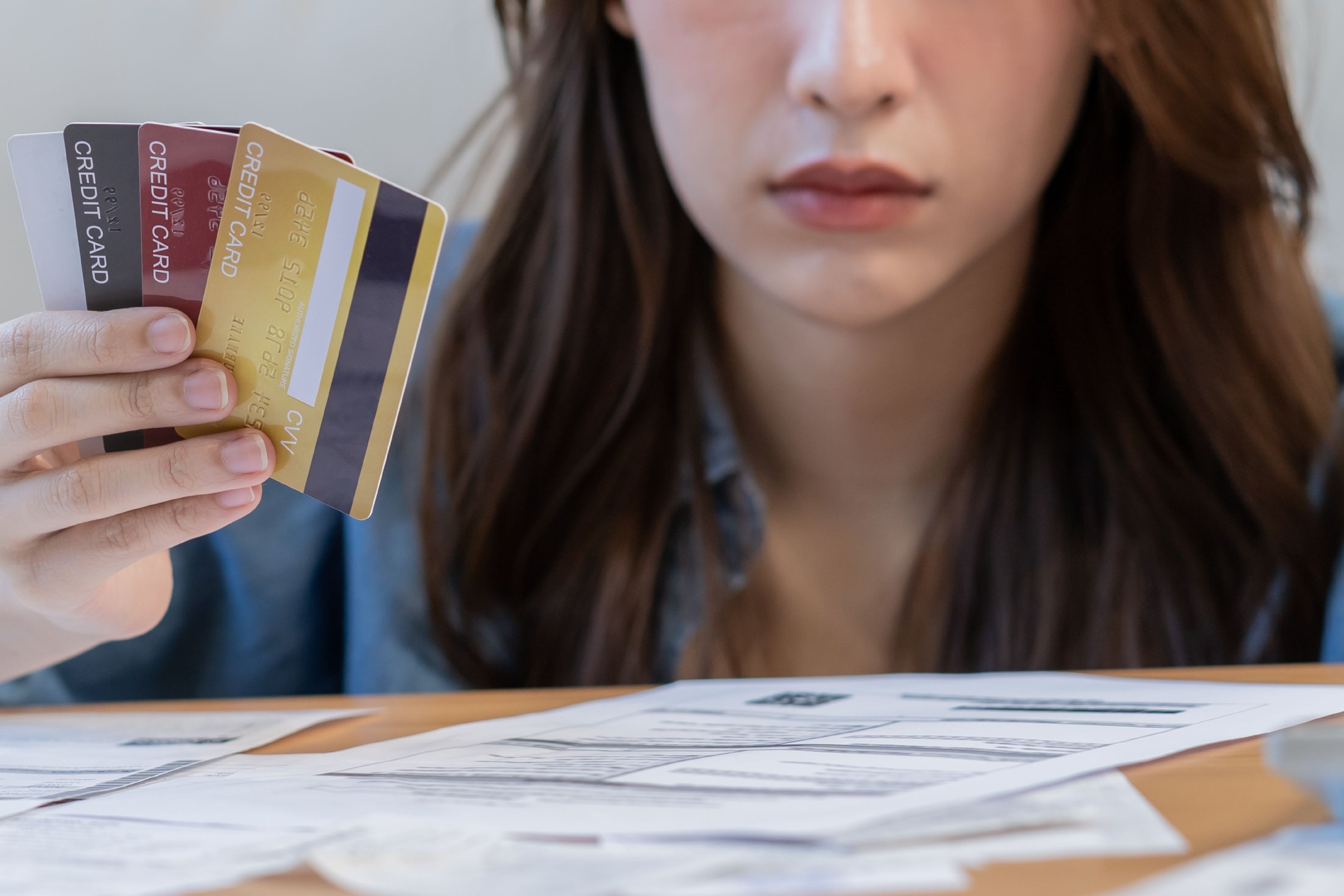 confused person holding multiple credit cards