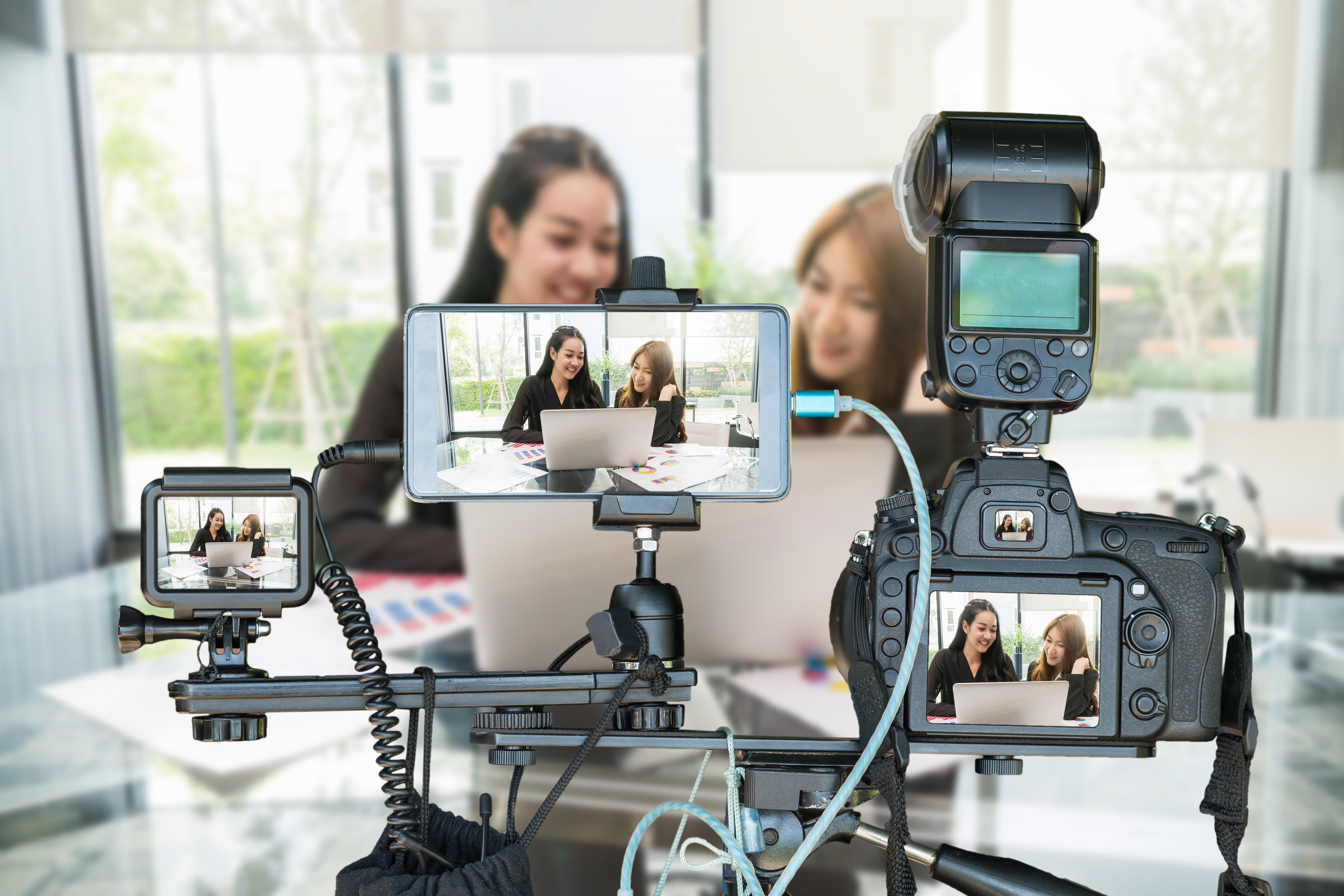 Two women using different types of cameras to record themselves