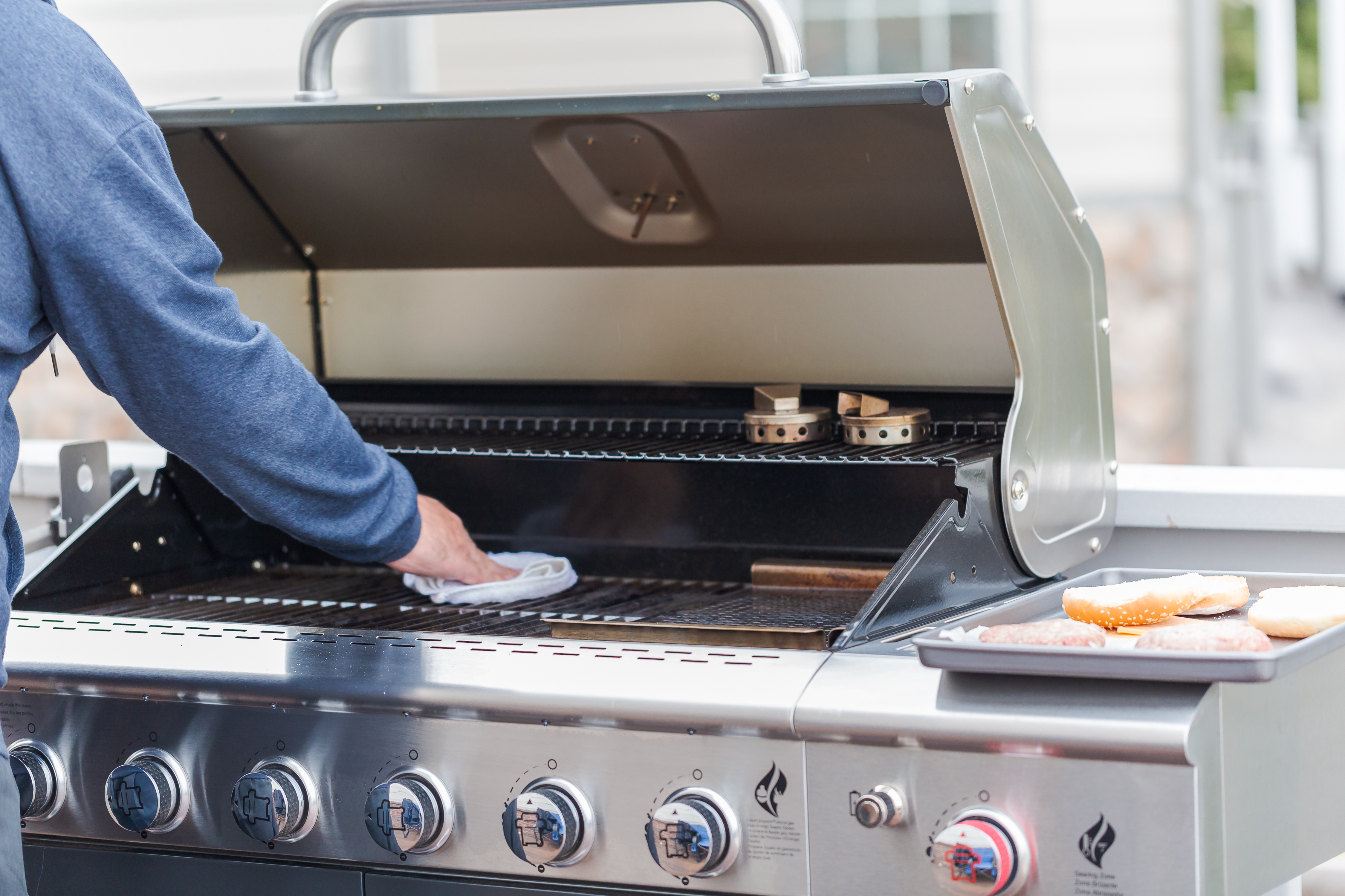 Person cleaning an outdoor grill