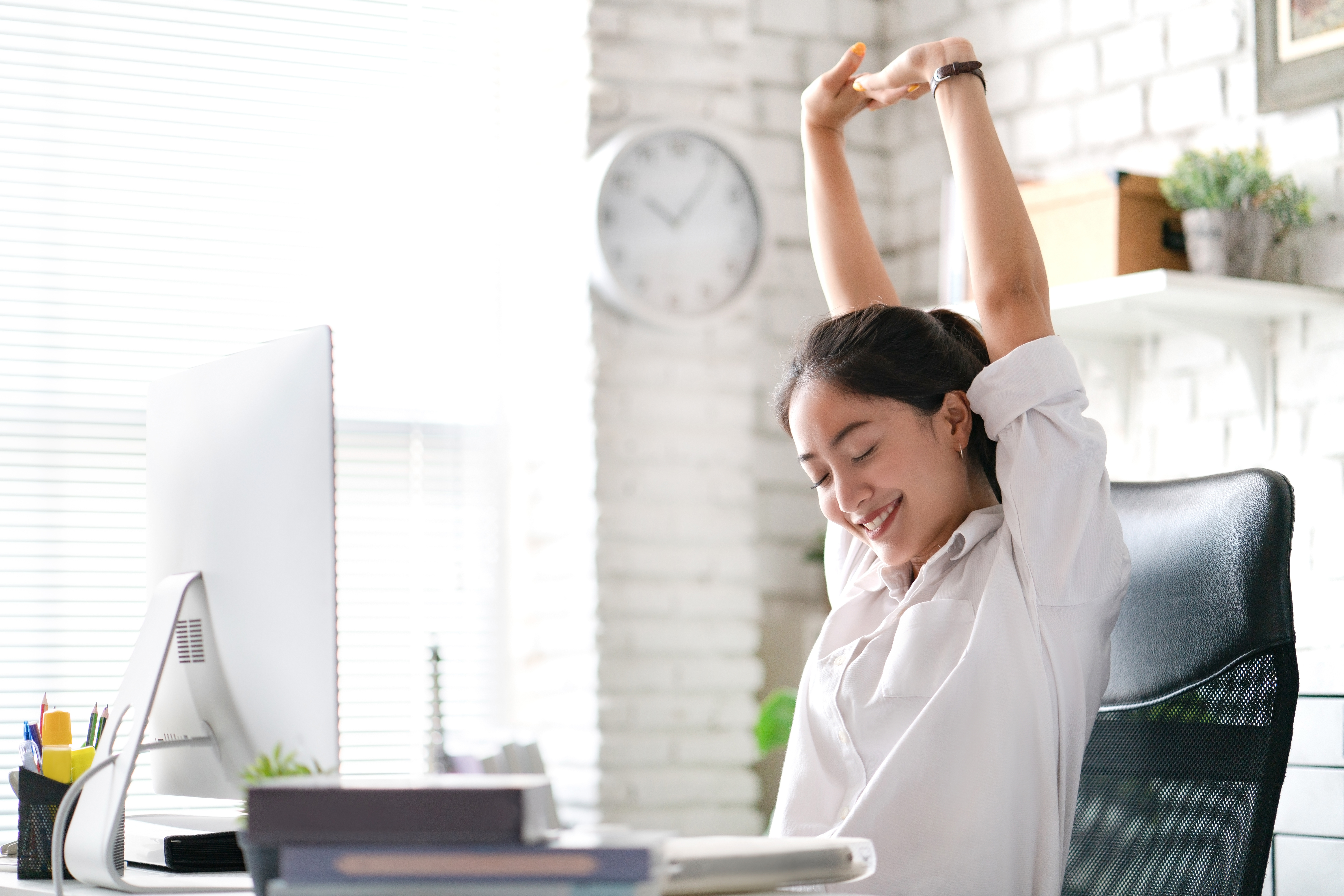 Woman sitting in an office chair and stretching