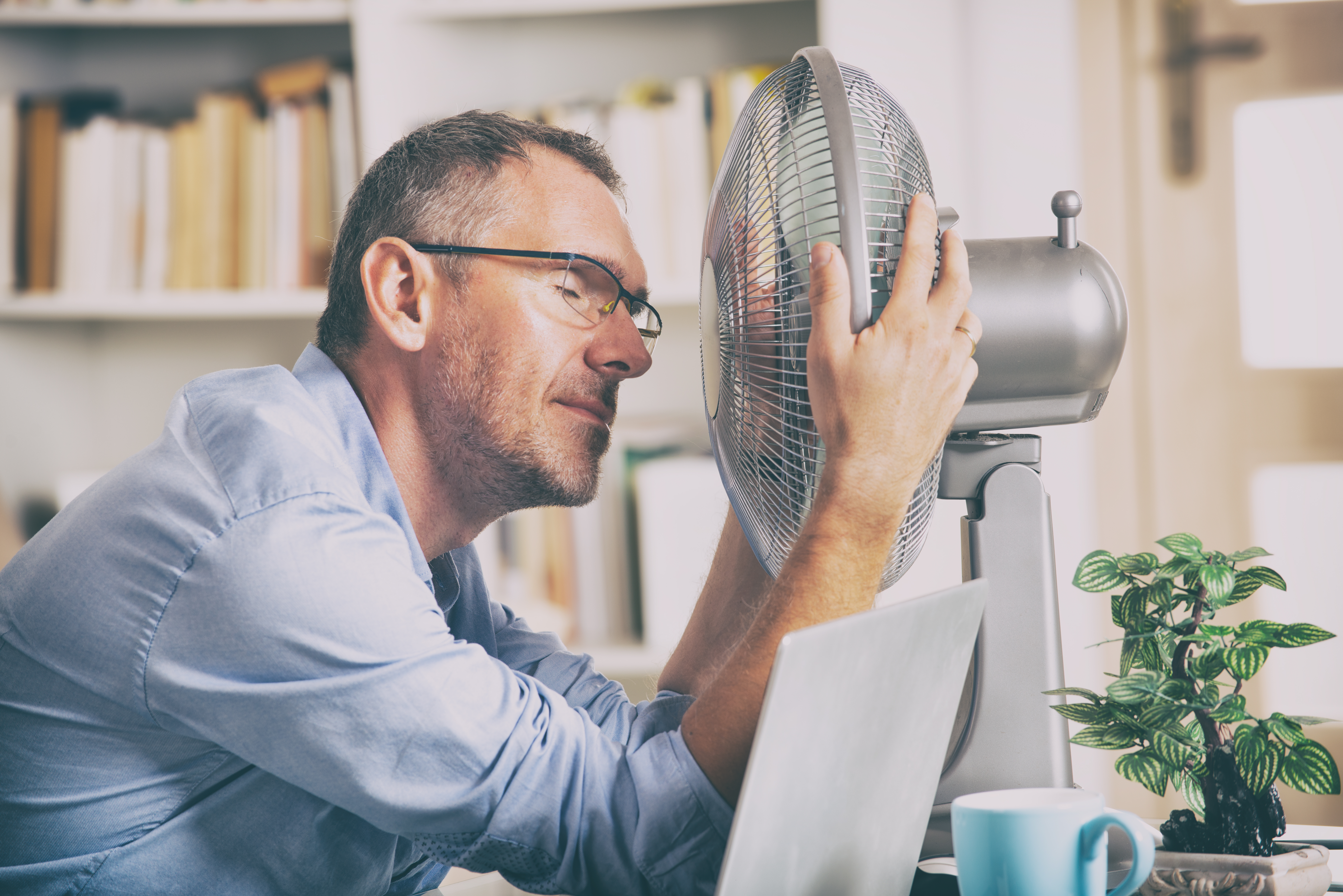 Man cooling off in front of a fan