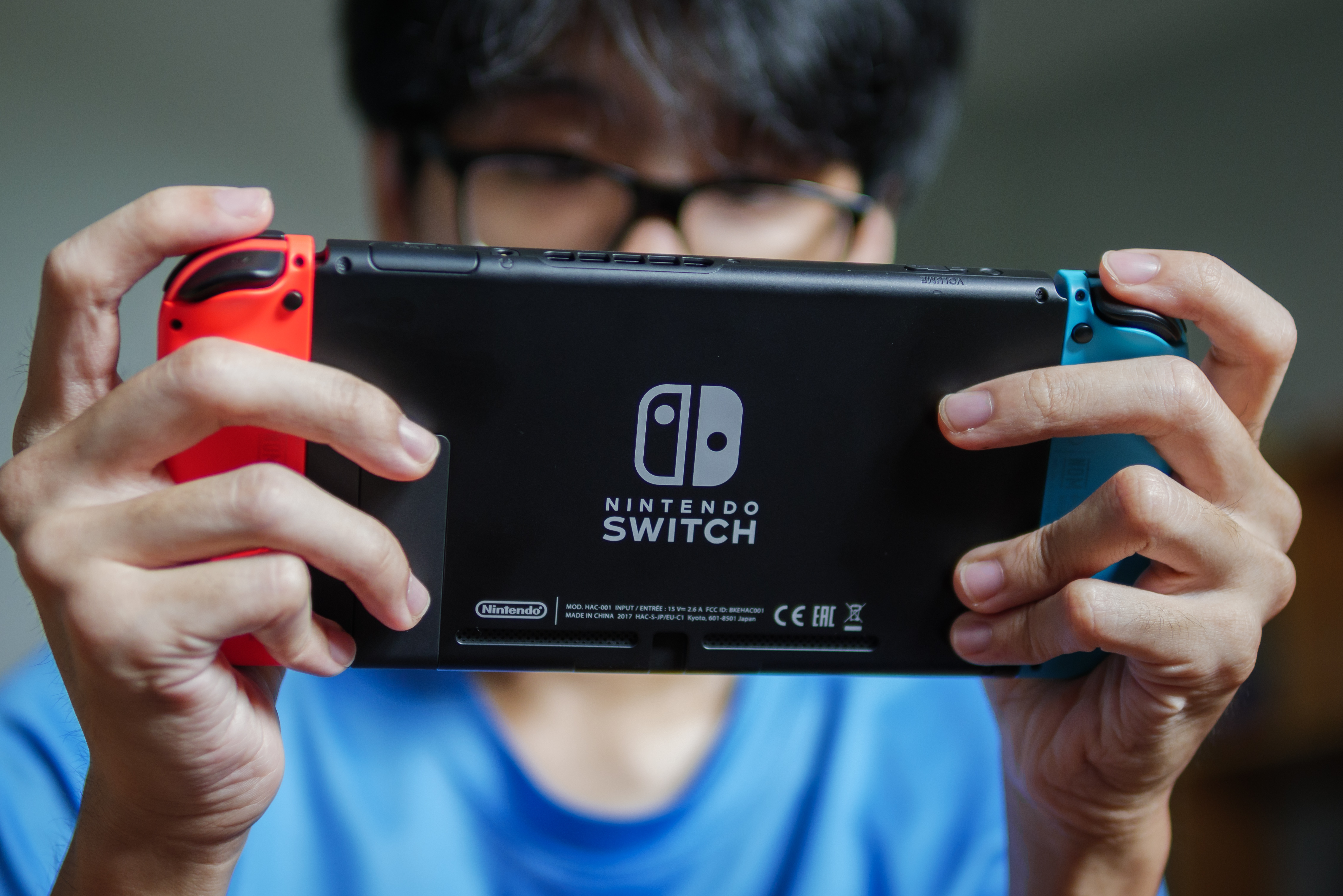 Kid wearing a blue shirt playing a Nintendo Switch