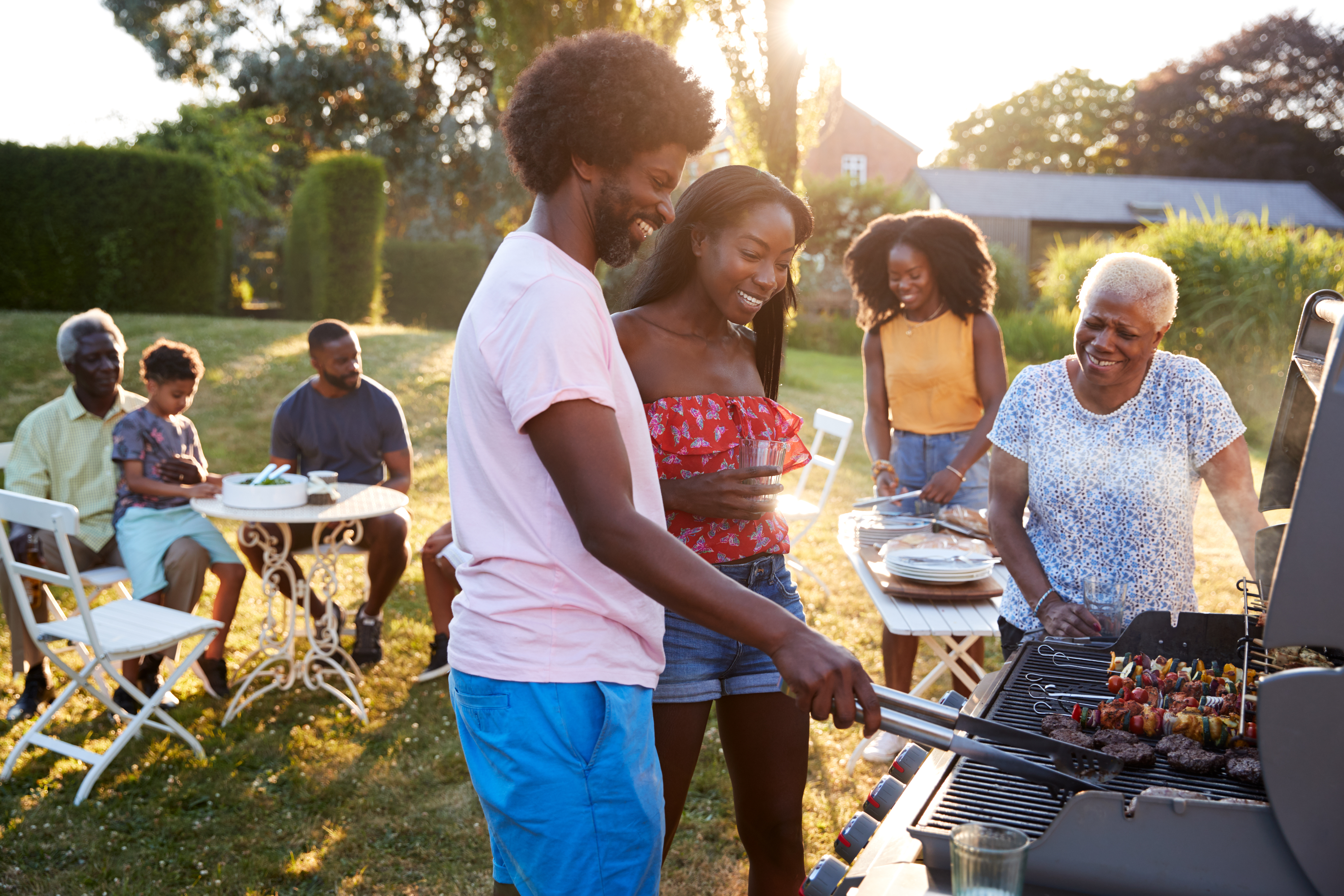 Group of people gathered outside around a grill