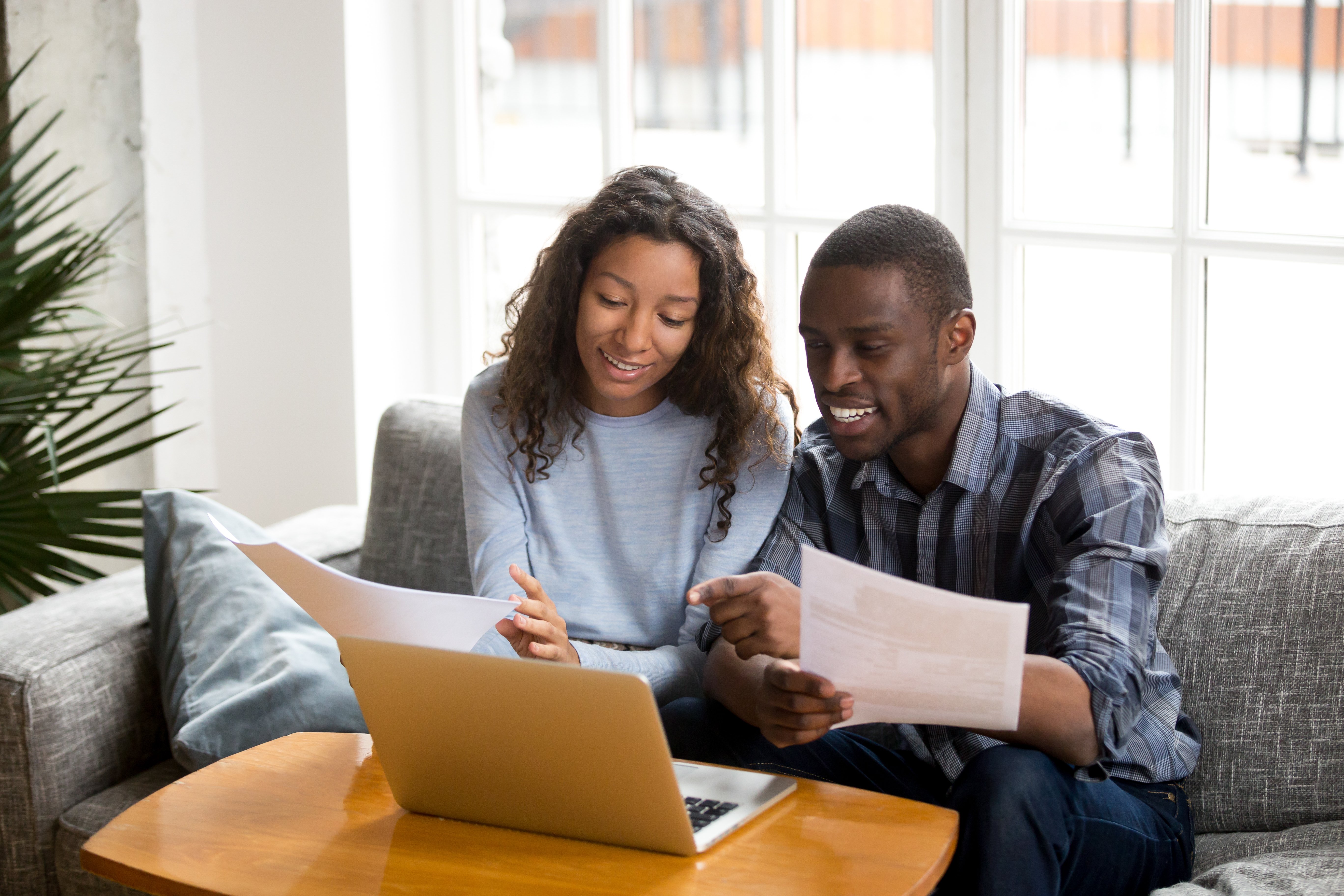 Man and woman sitting on a couch looking at a computer