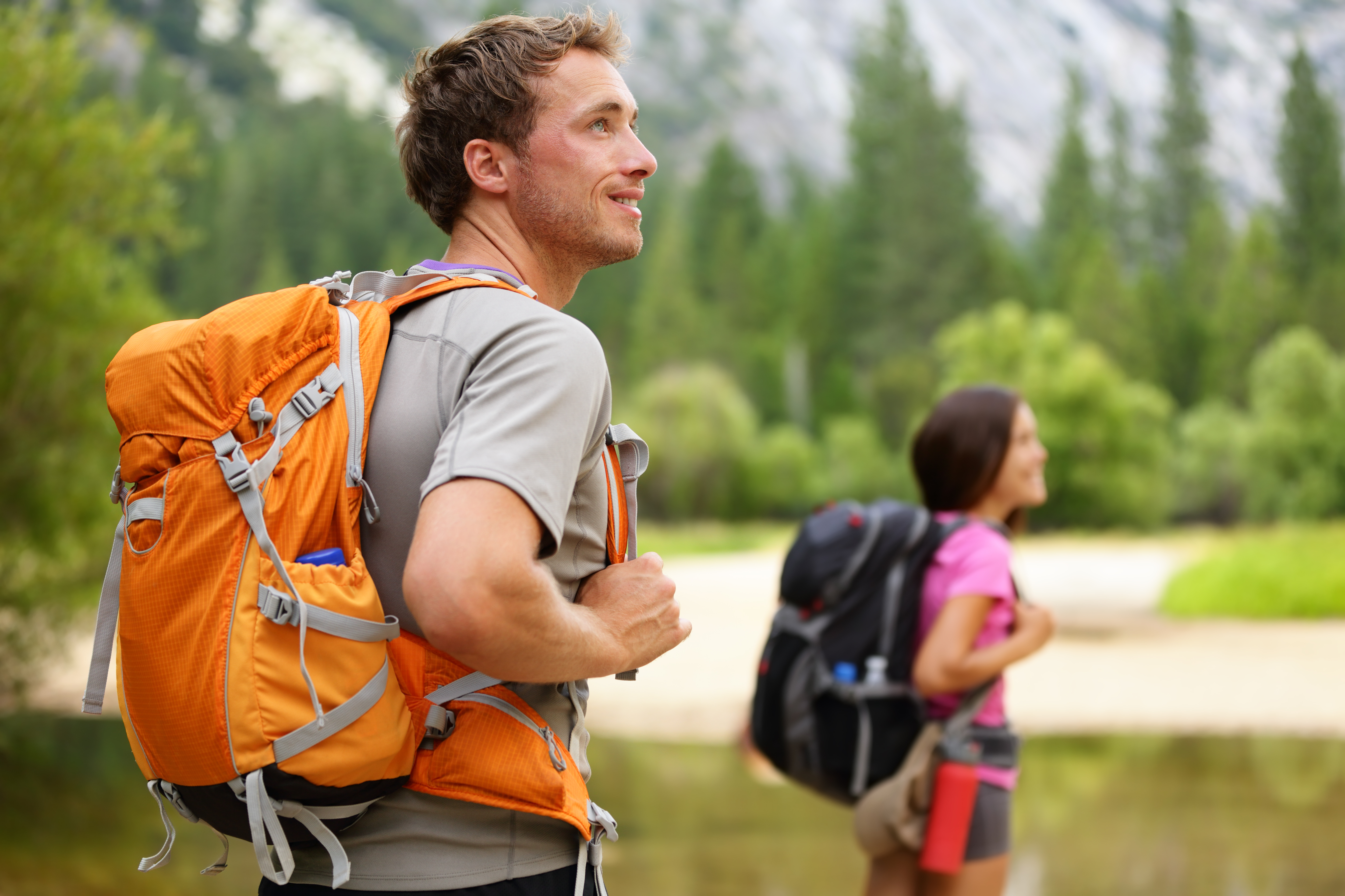 Man and woman wearing hiking backpacks on a hike