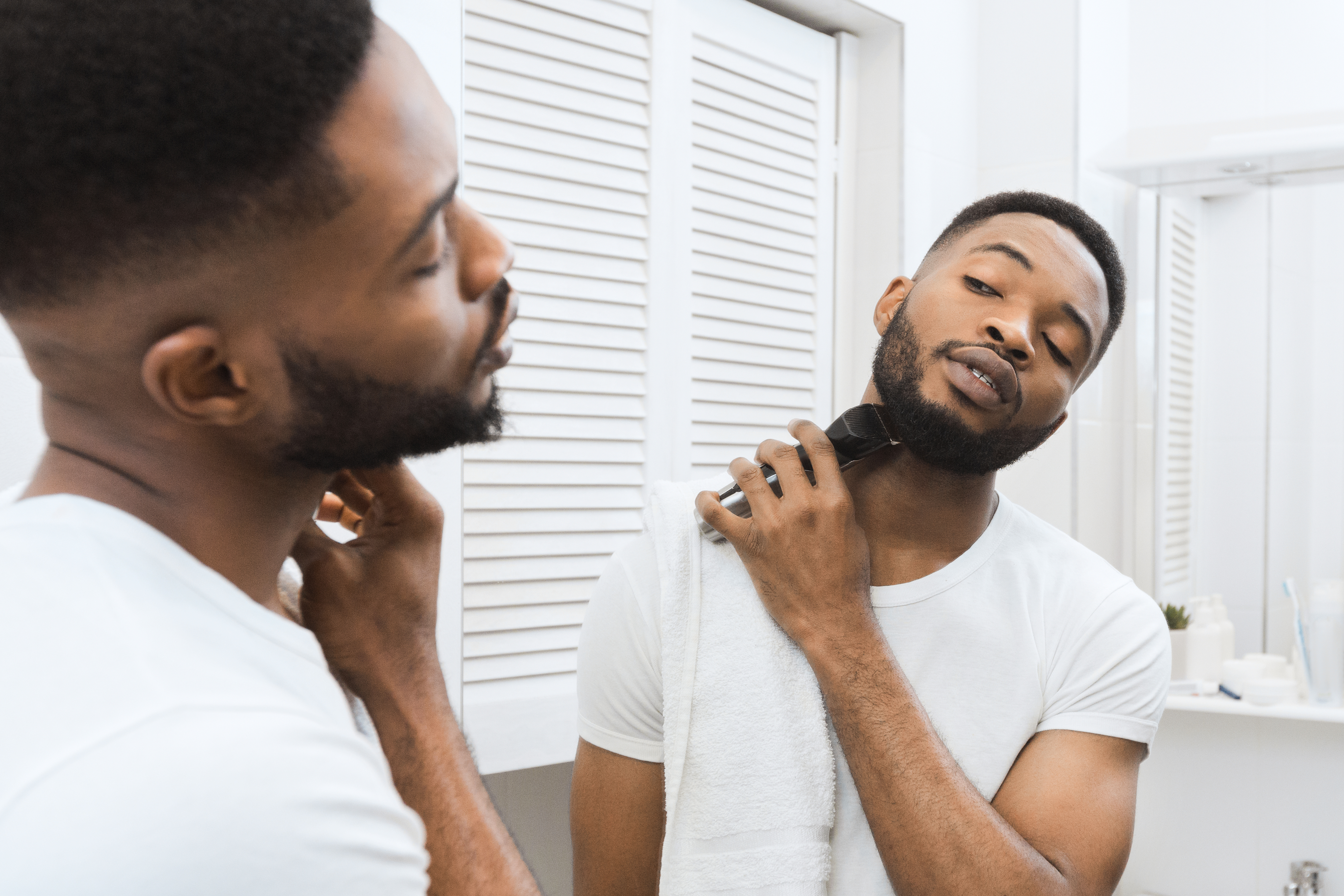 Man looking in the mirror using an electric shaver