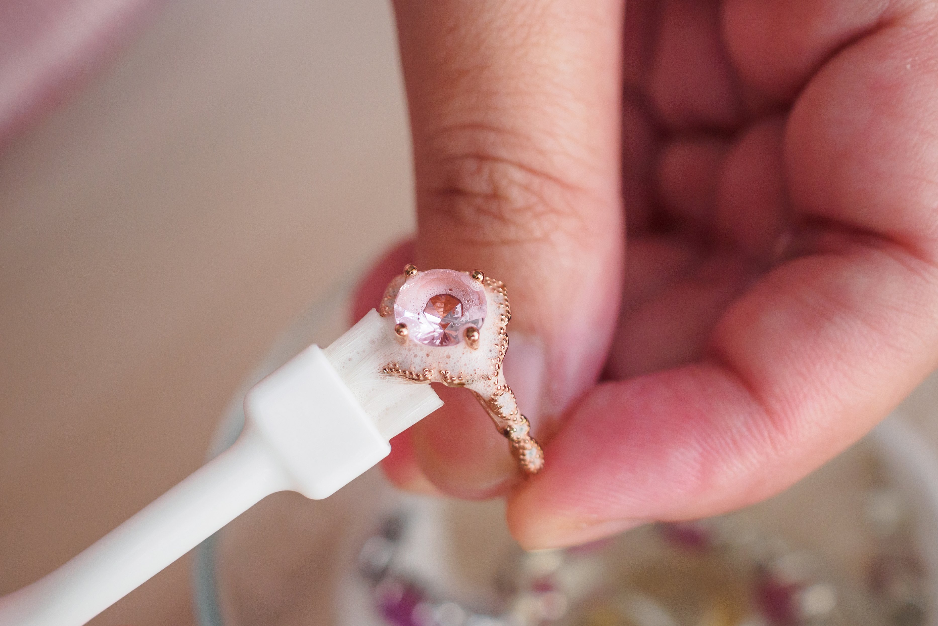 person cleaning a gold ring