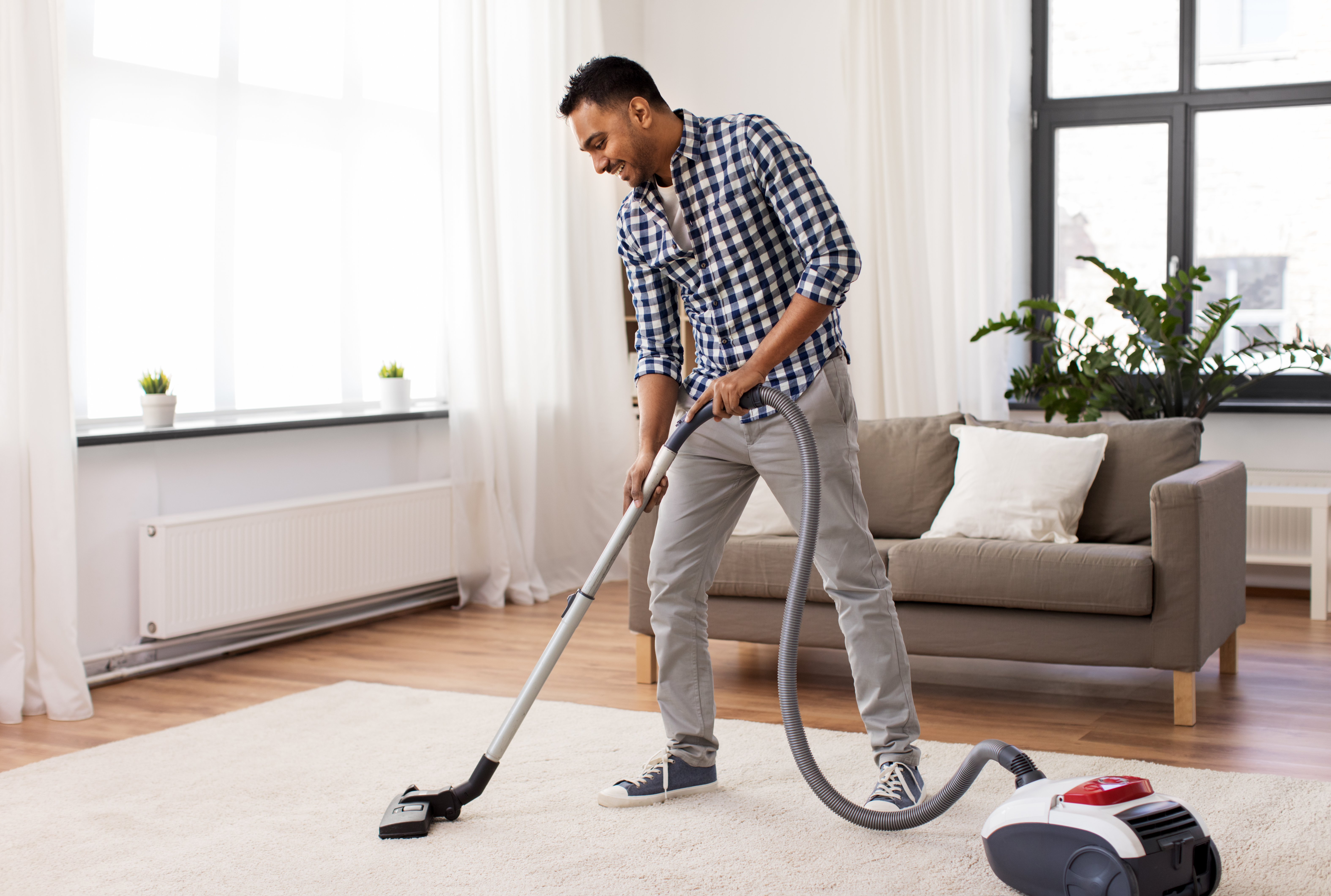 Man vacuuming in his living room