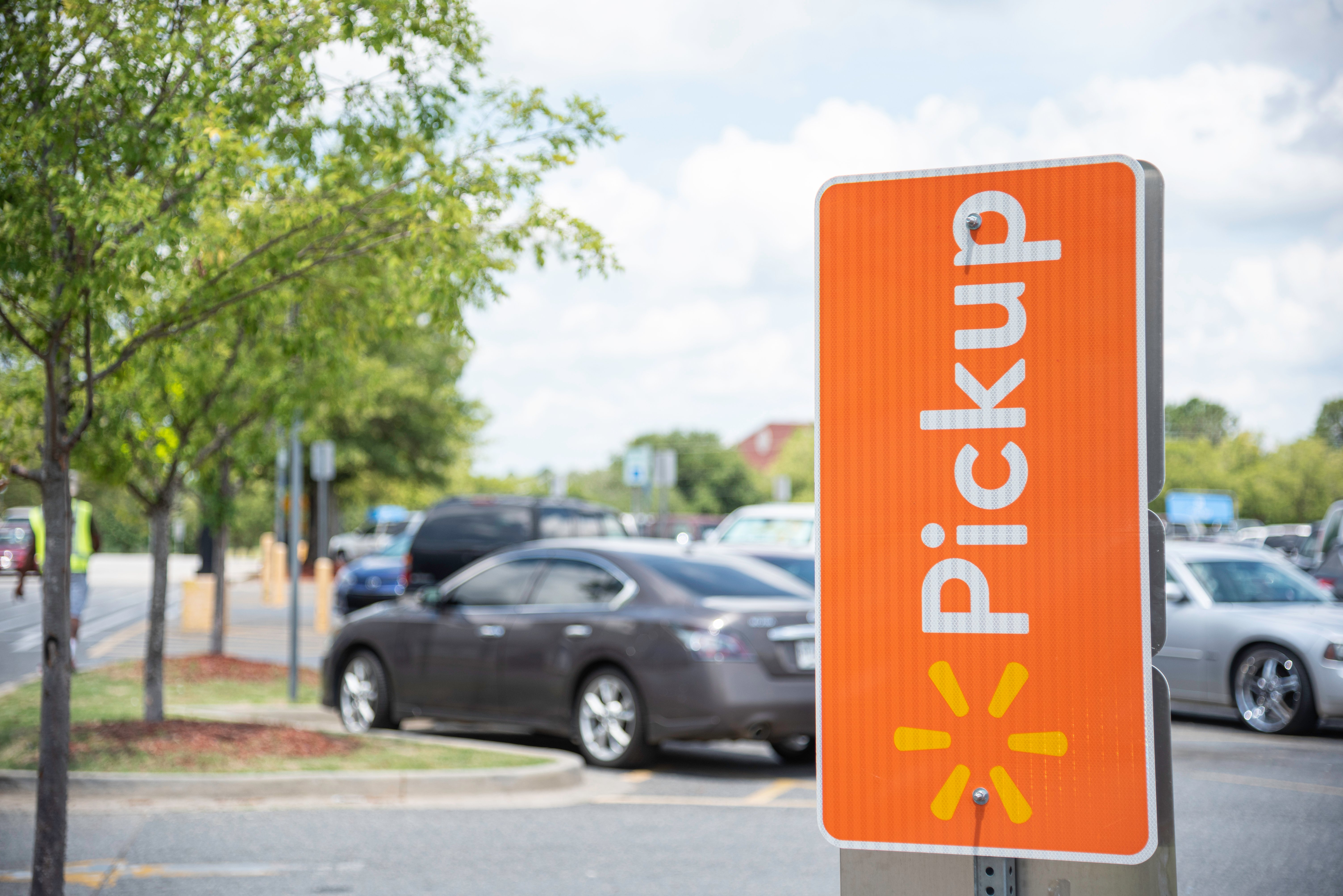 Orange sign for Walmart pickup in a Walmart parking lot