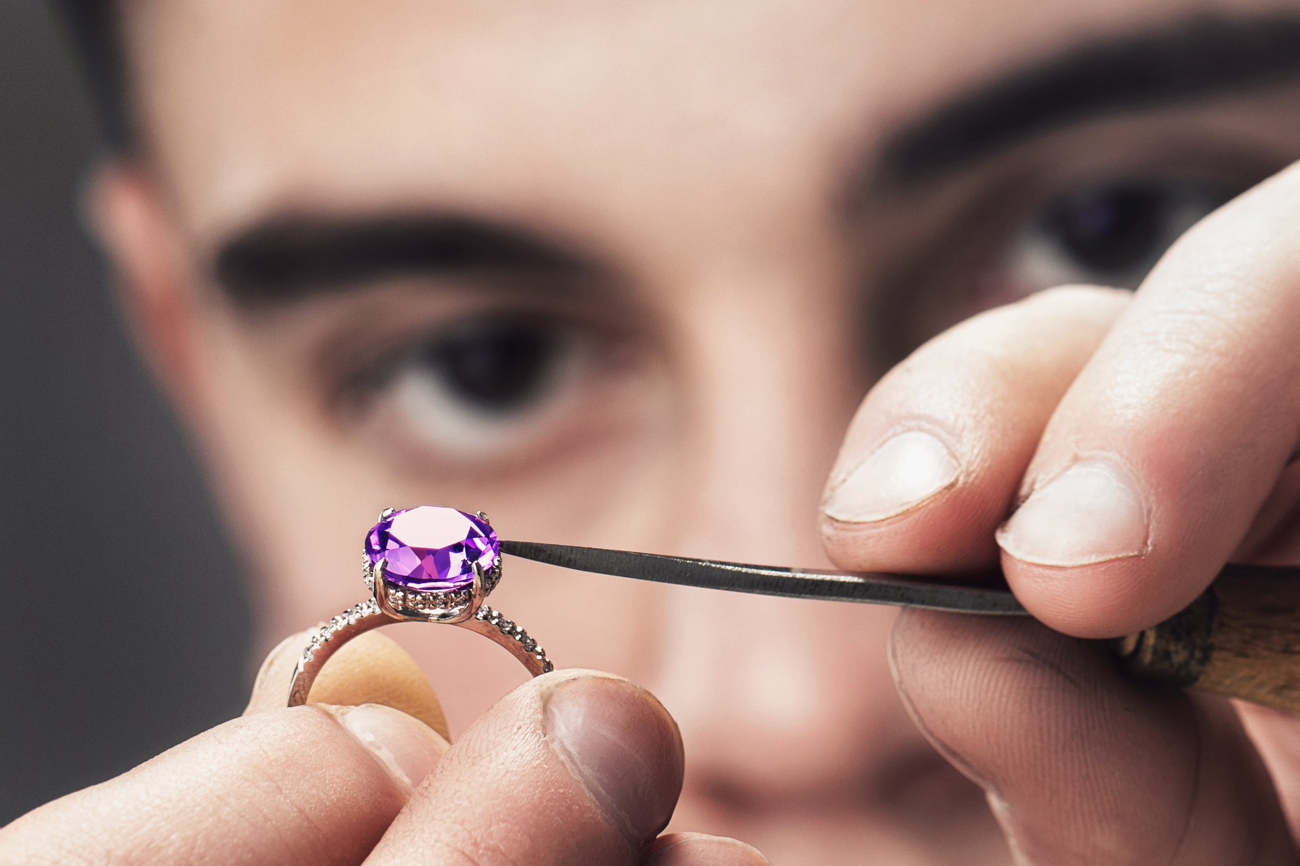 person repairing gemstone in ring