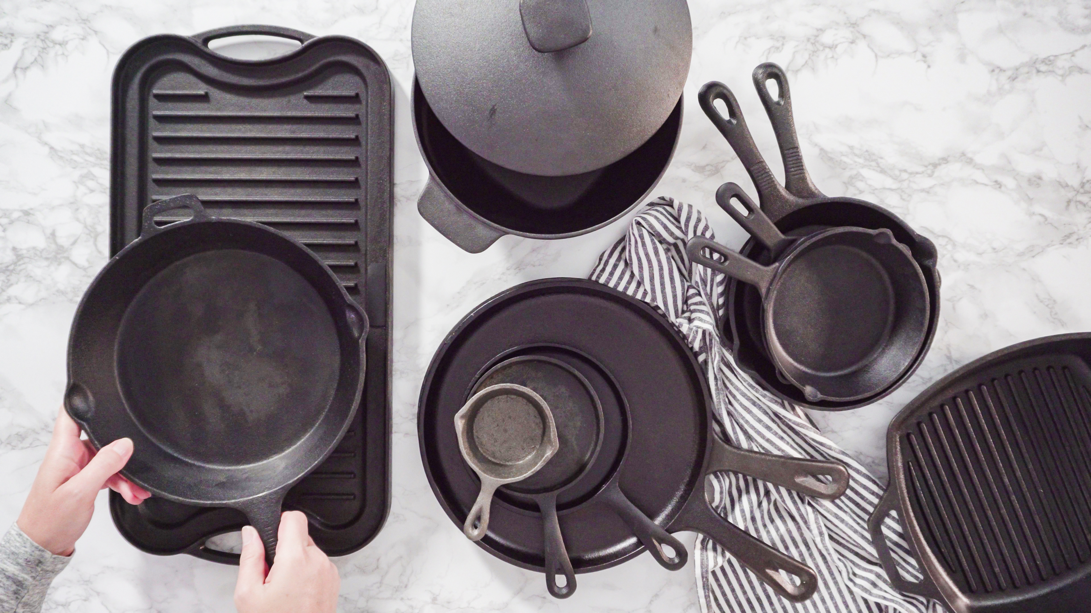 Overhead view of several different types of cast iron skillets on a table