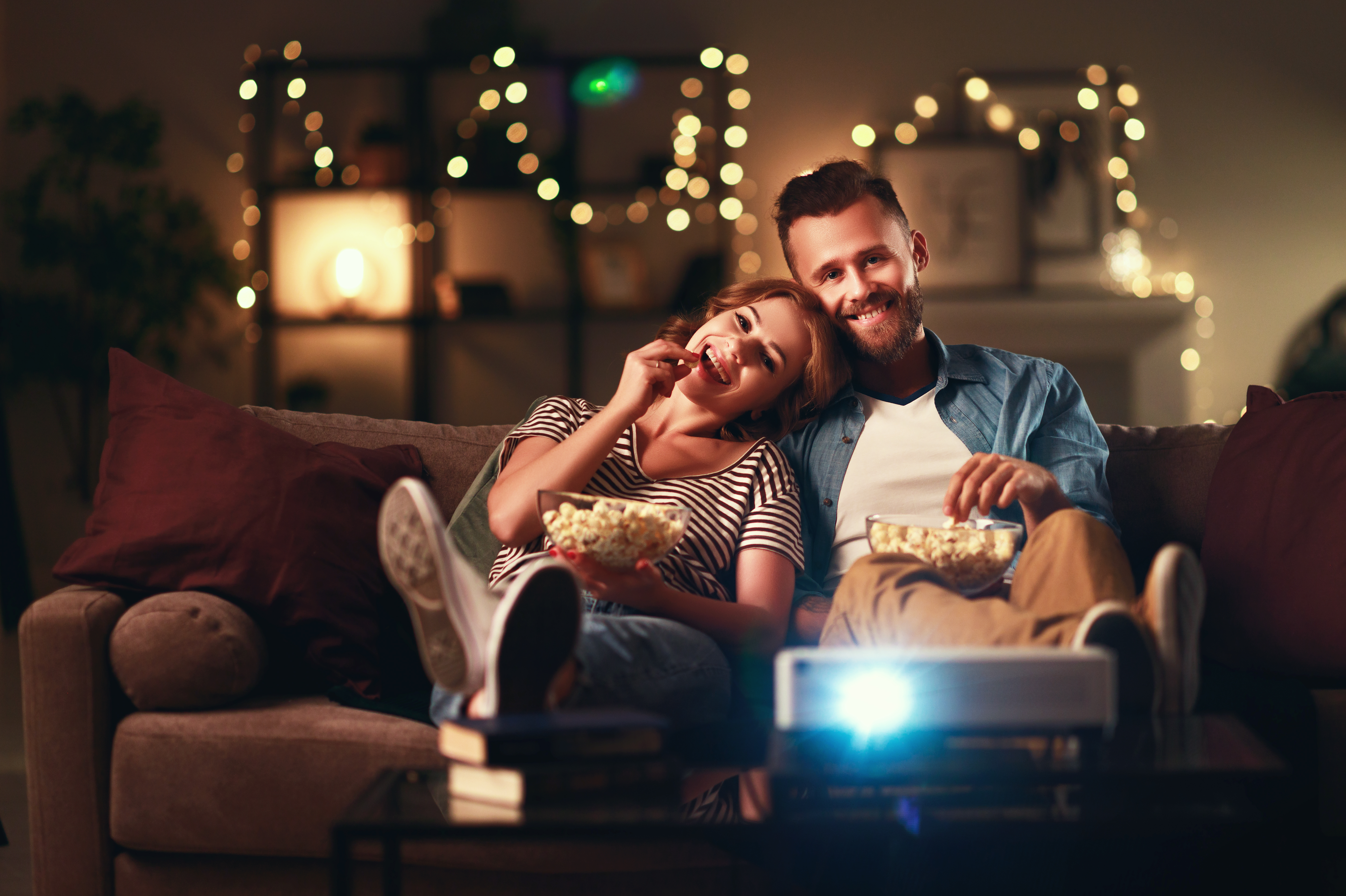 Man and woman watching a movie on a projector