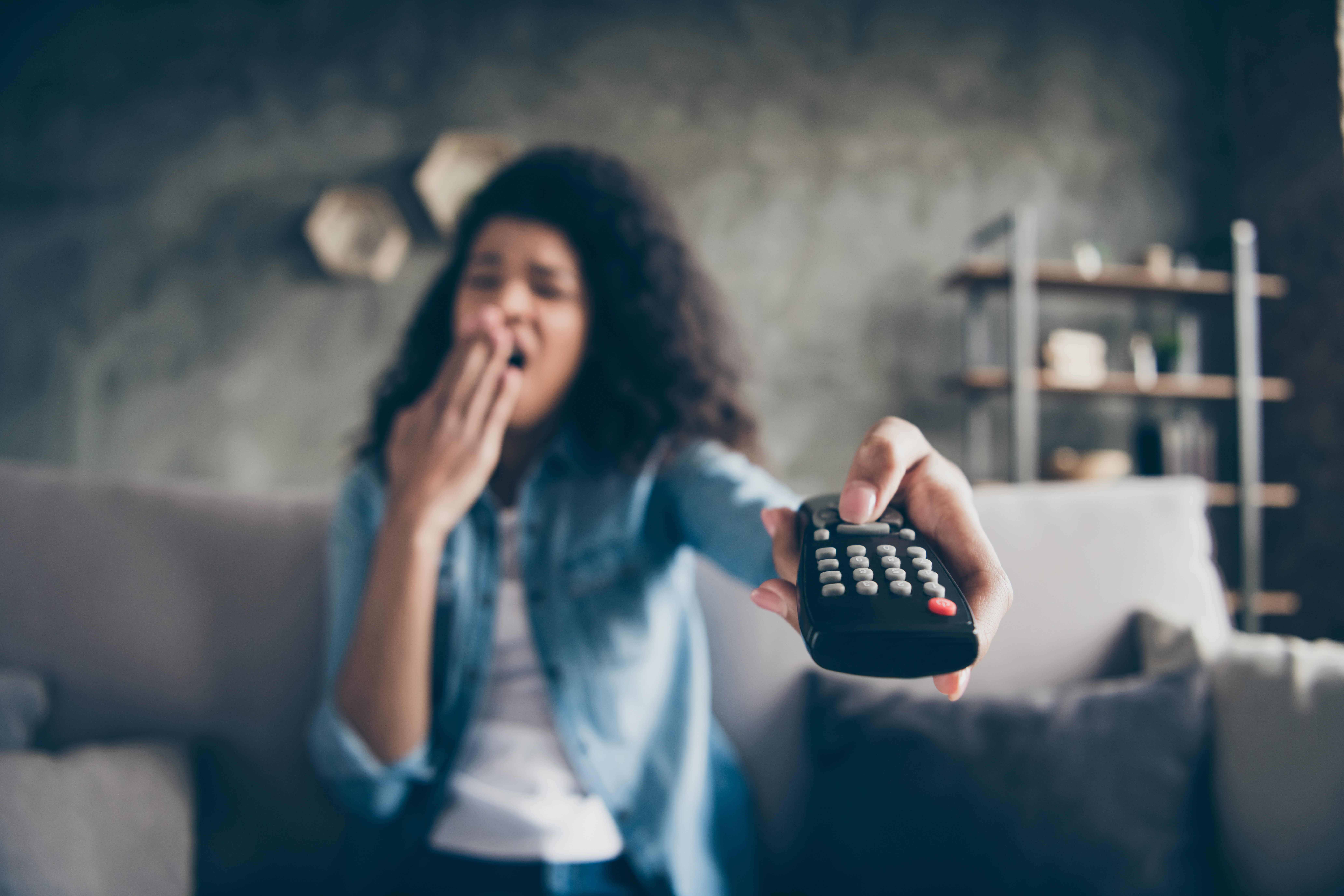 Woman yawning and turning off tv