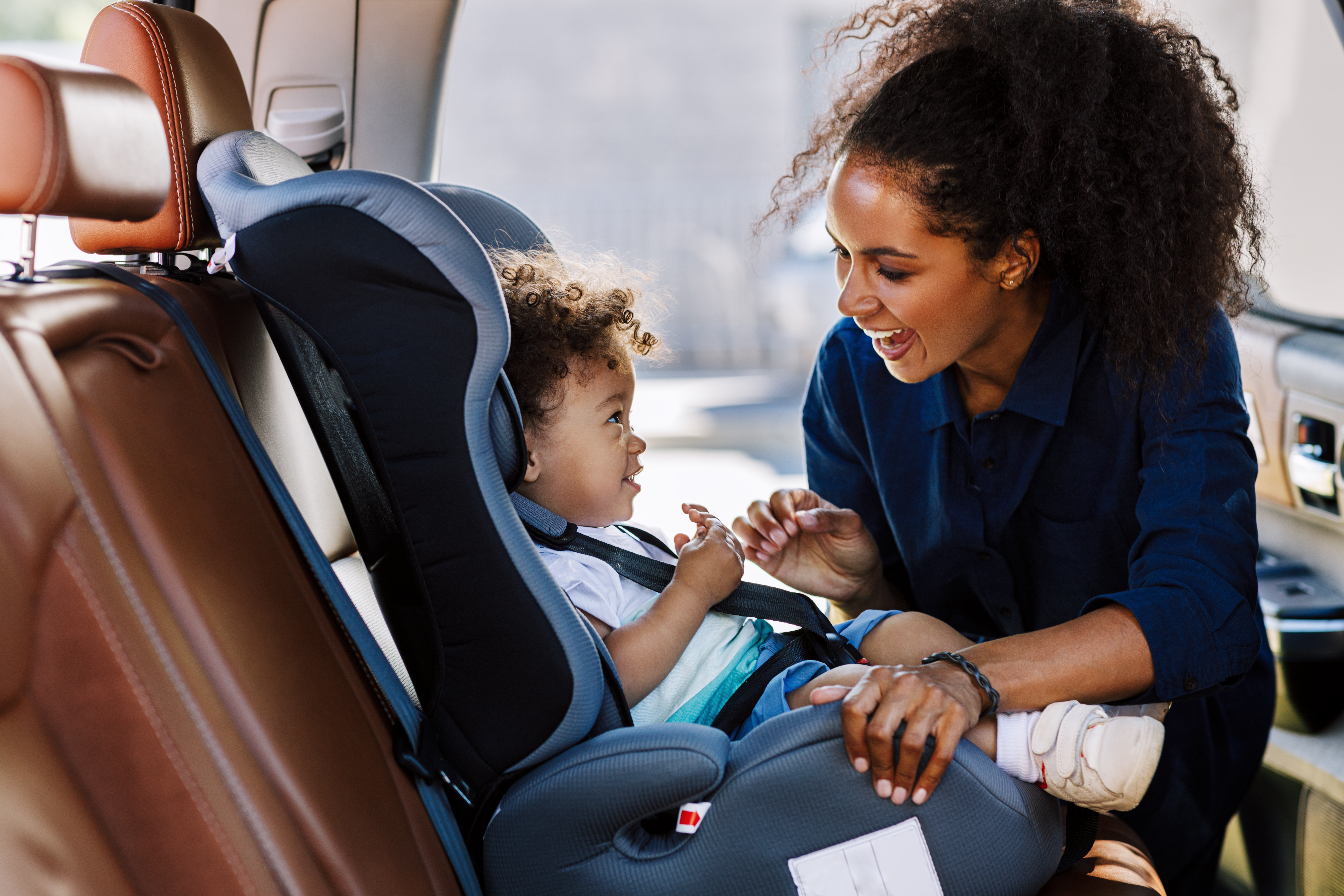 mom looking at child in car seat