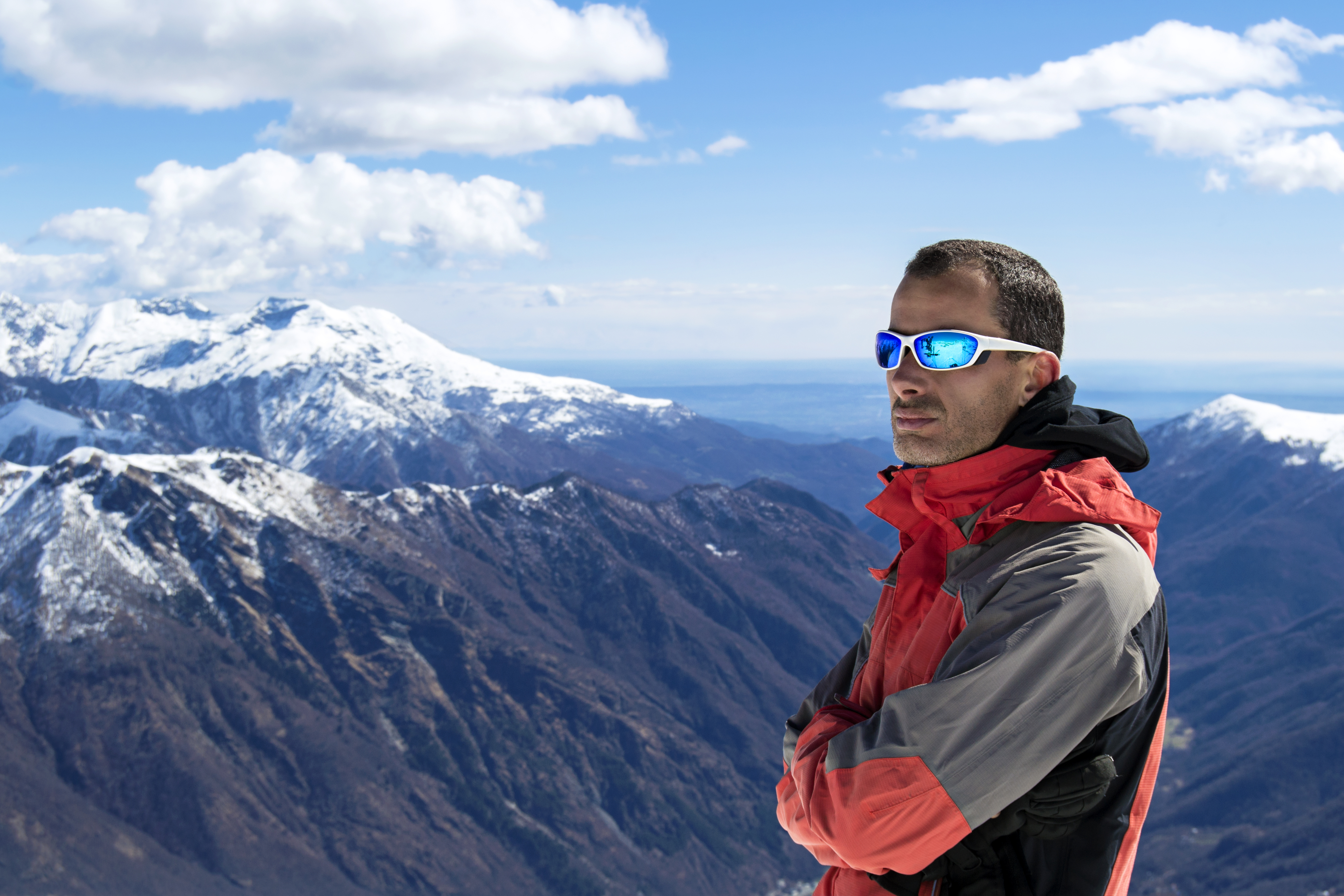 Man standing on top of a mountain wearing sunglasses