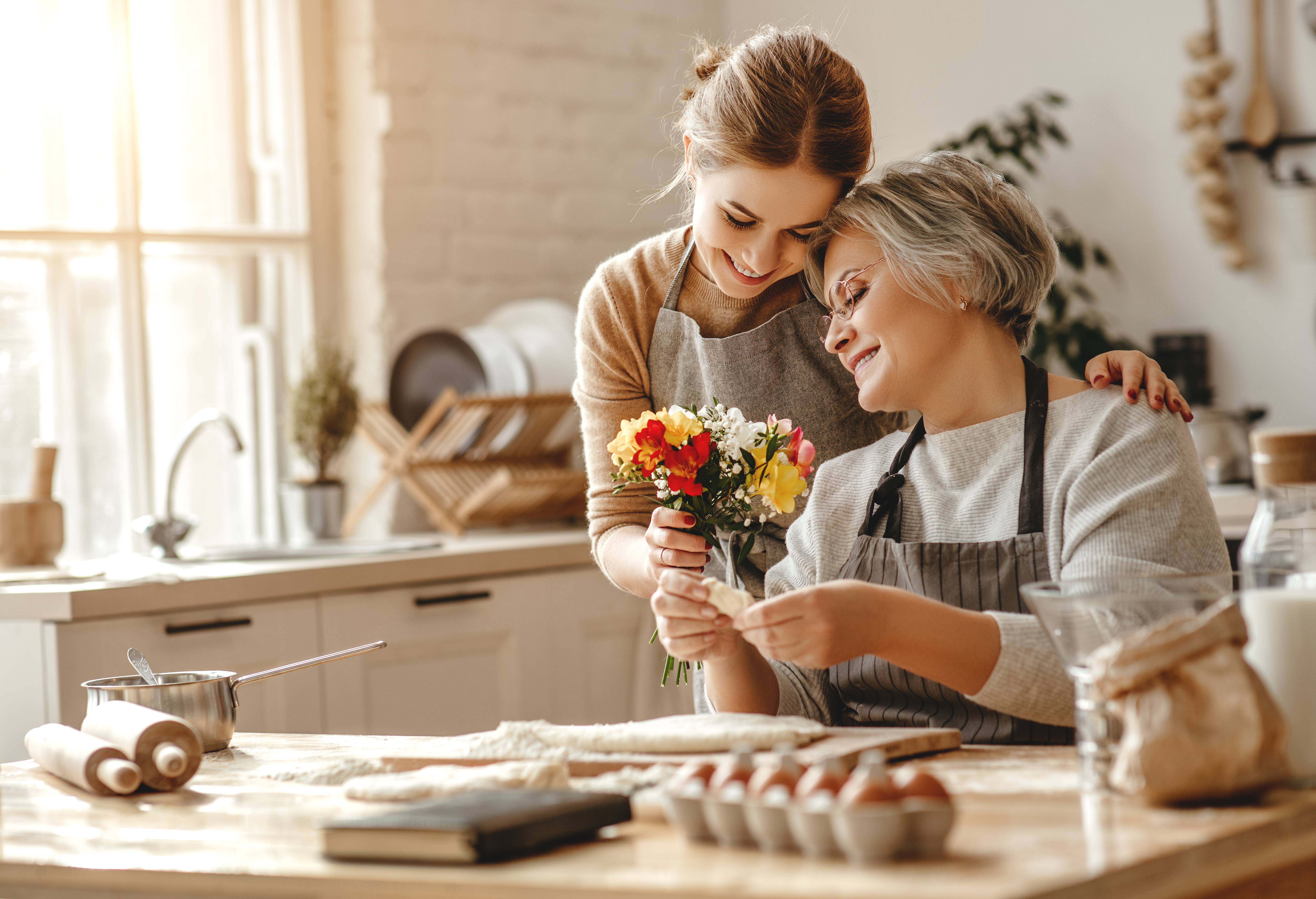 Mother and daughter smiling and cooking together