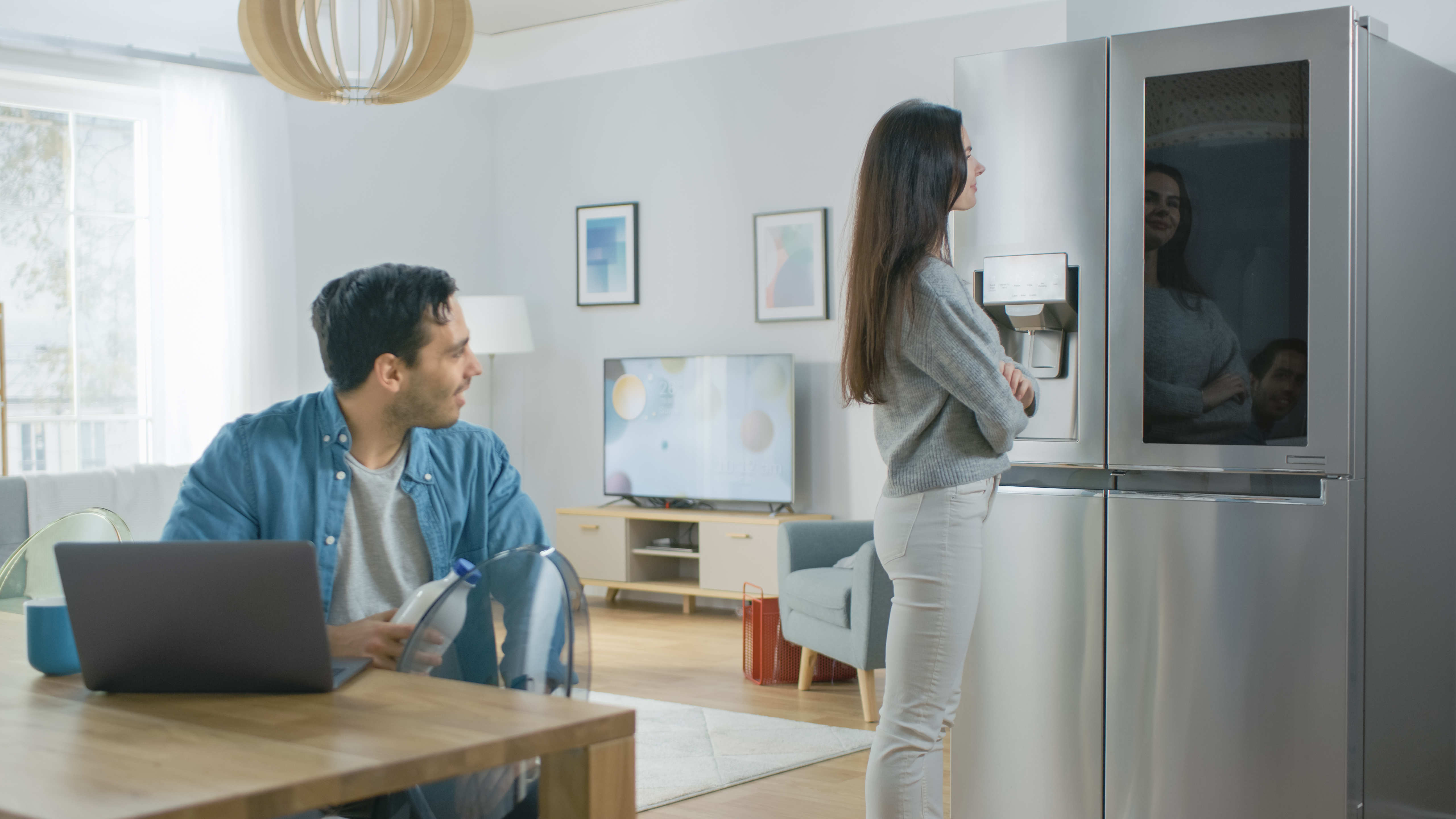 Man and woman looking at a refrigerator in their kitchen