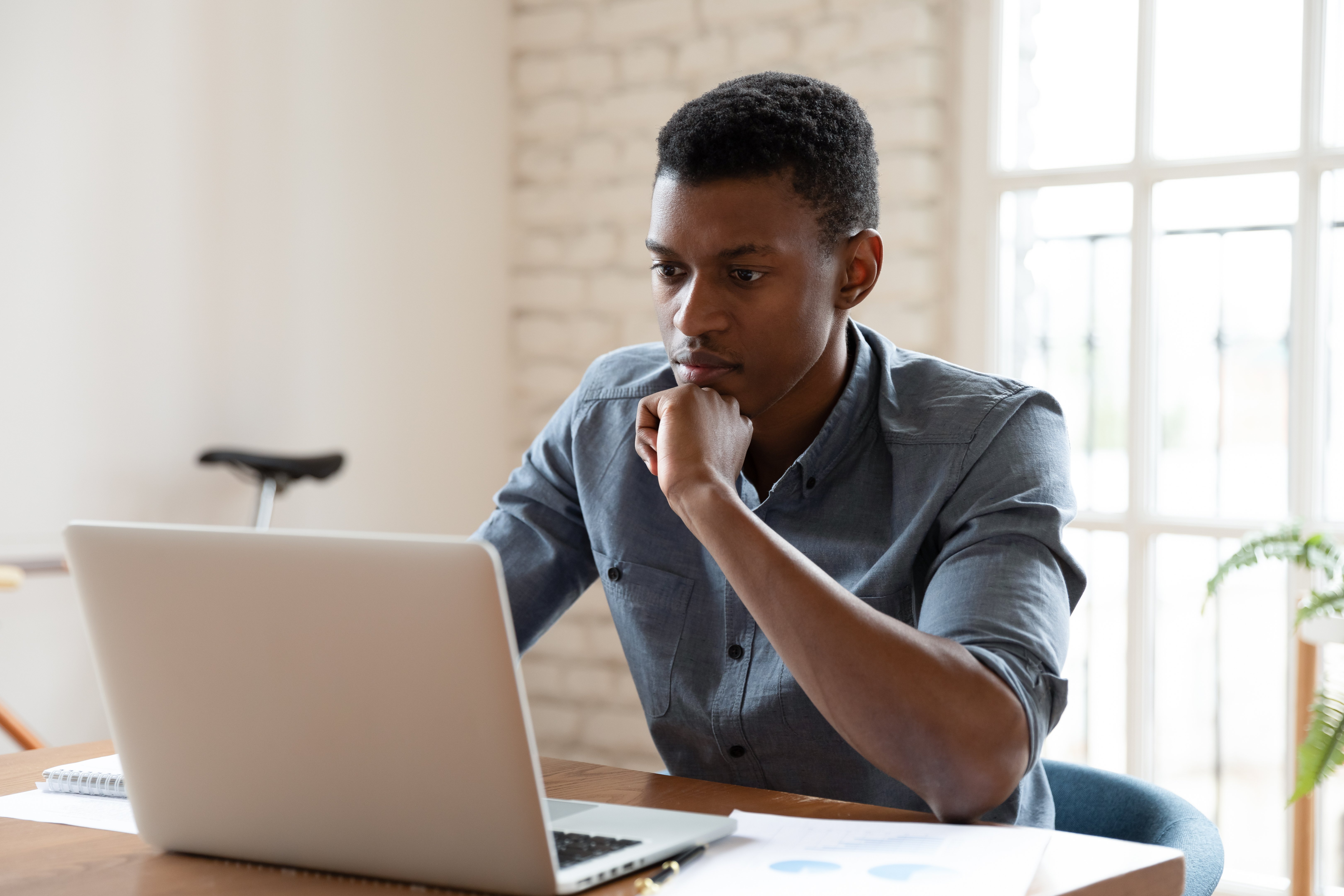 Man sitting at his laptop thinking