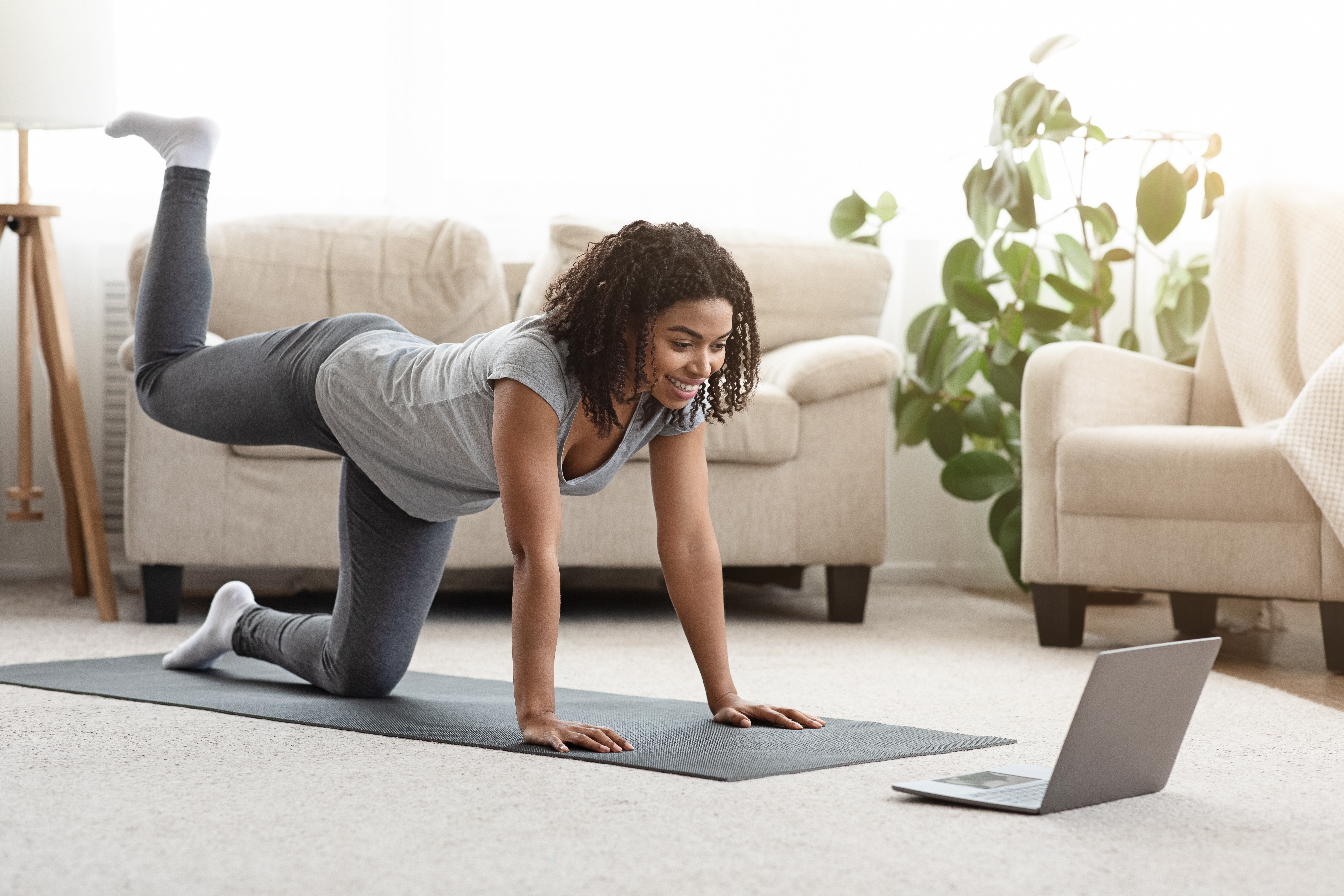 Woman doing a yoga class on her laptop