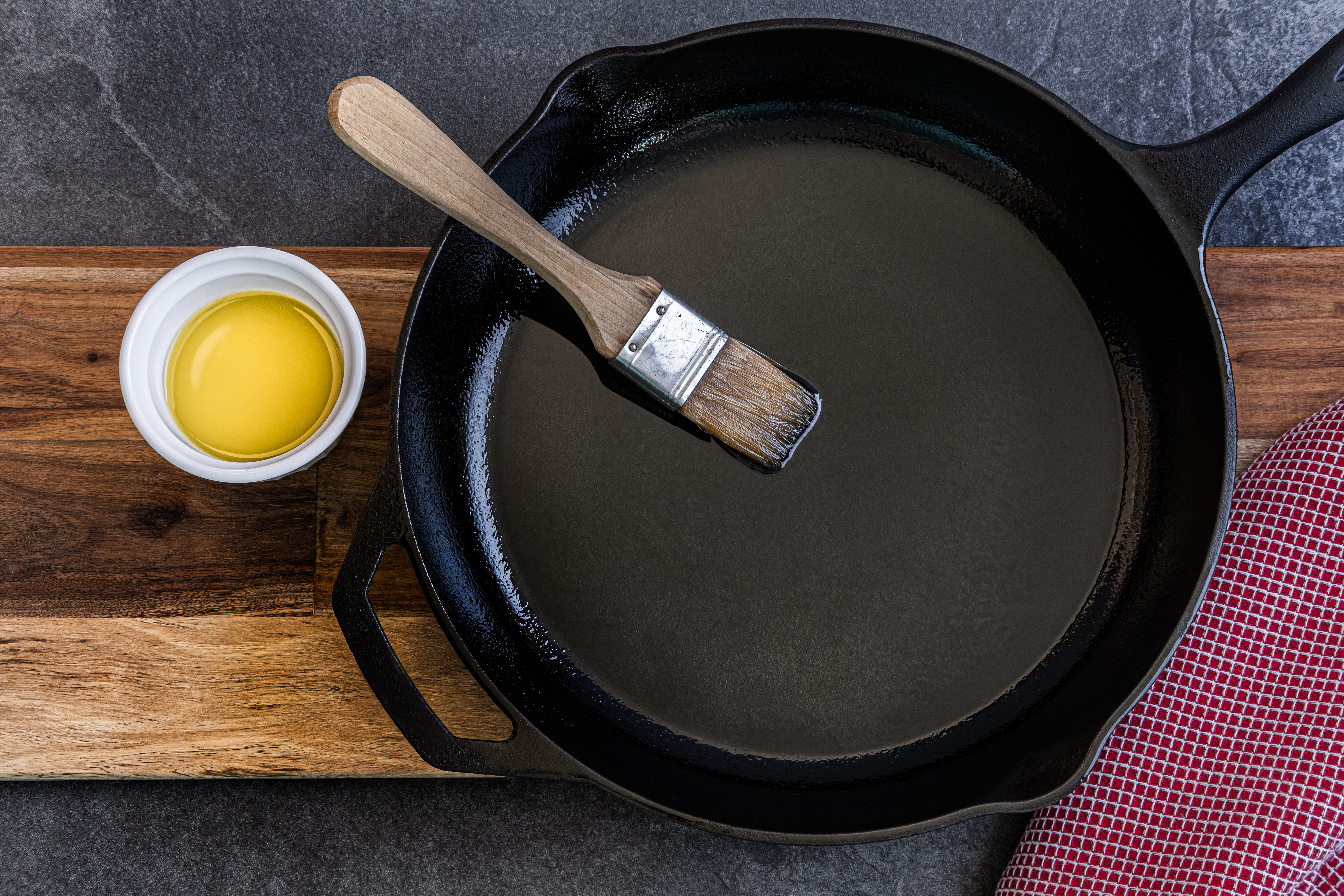 Cast iron skillet being brushed with olive oil