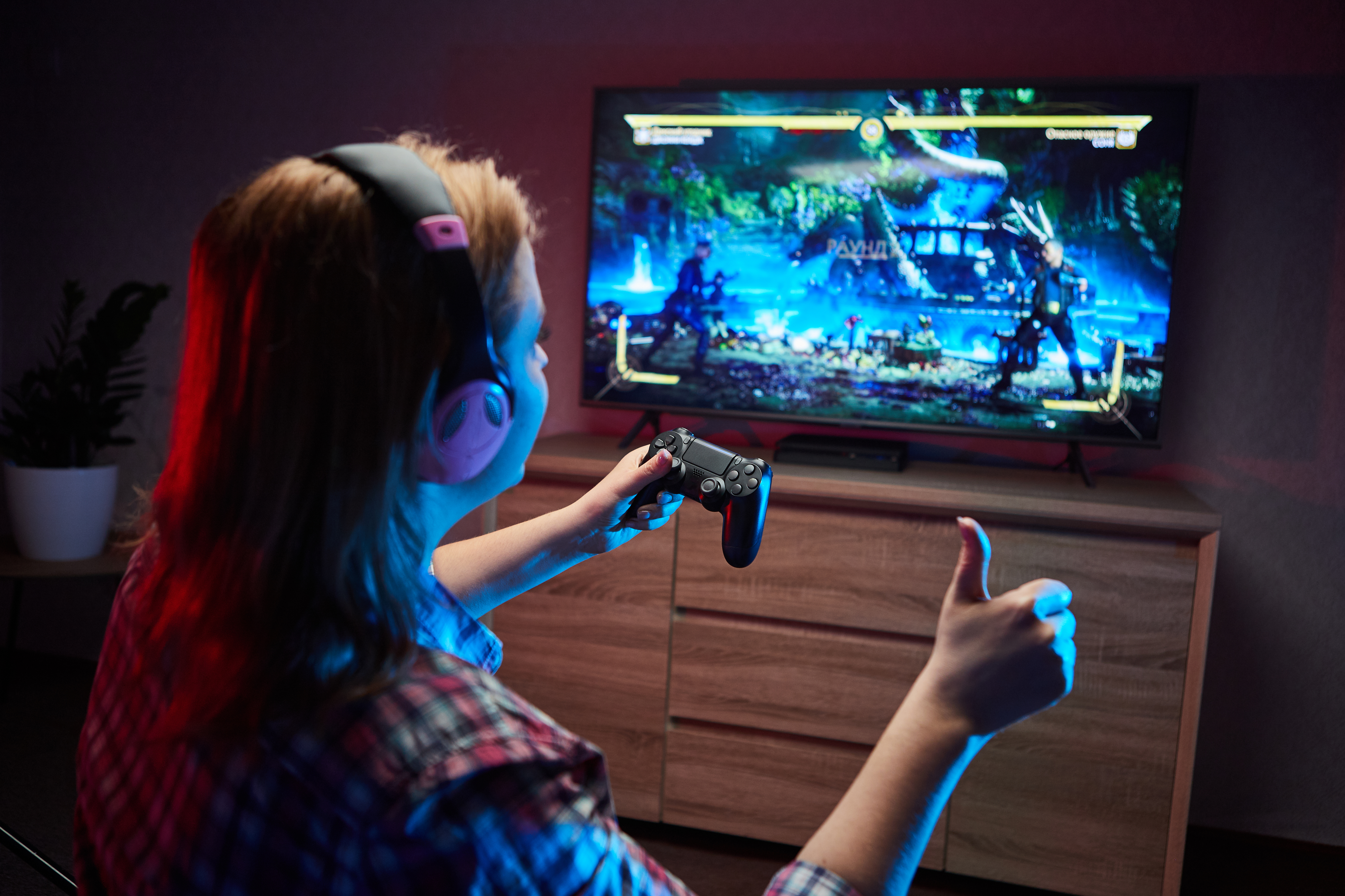 Woman playing video games giving a thumbs up