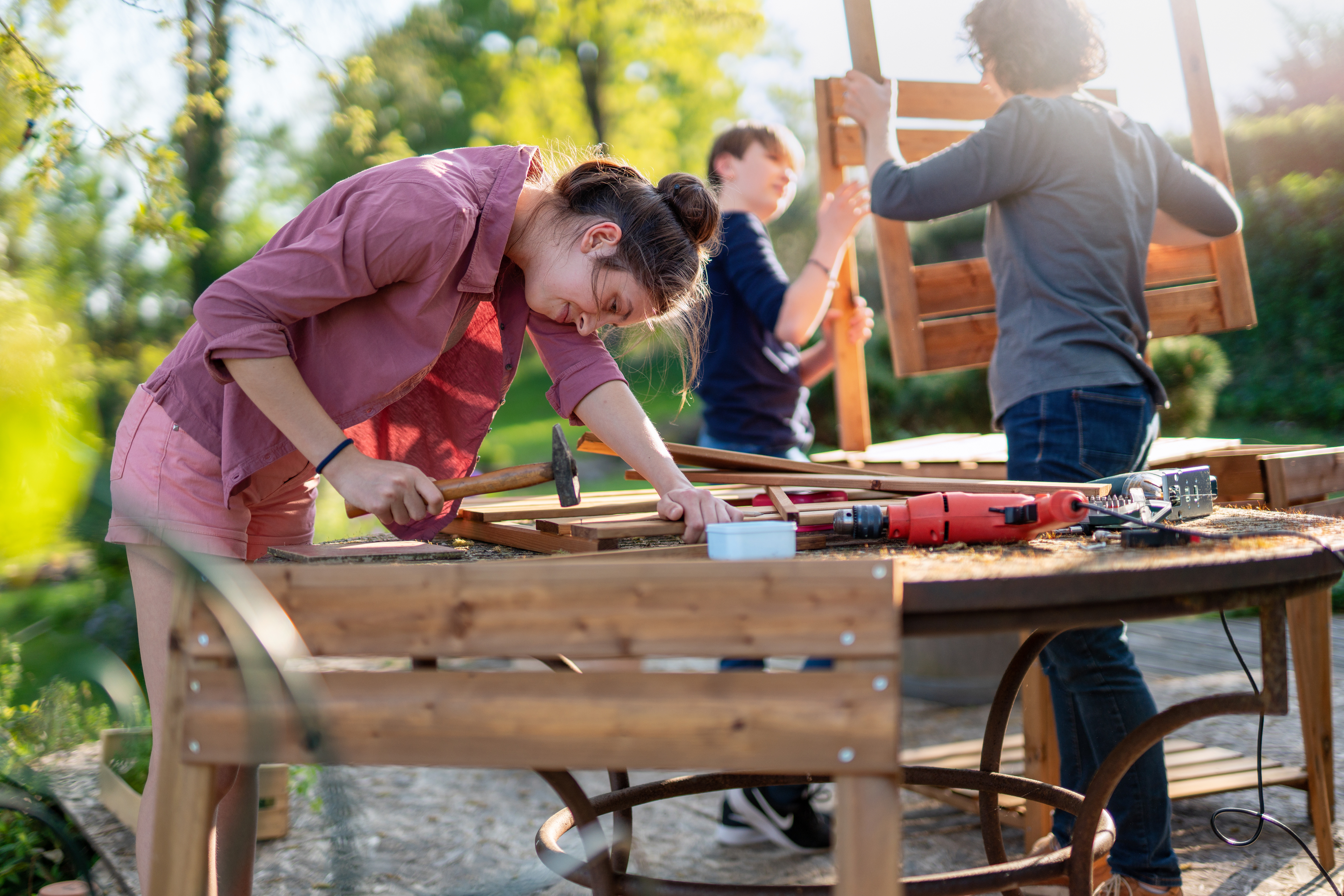 Woman hammering a nail while working on a DIY project