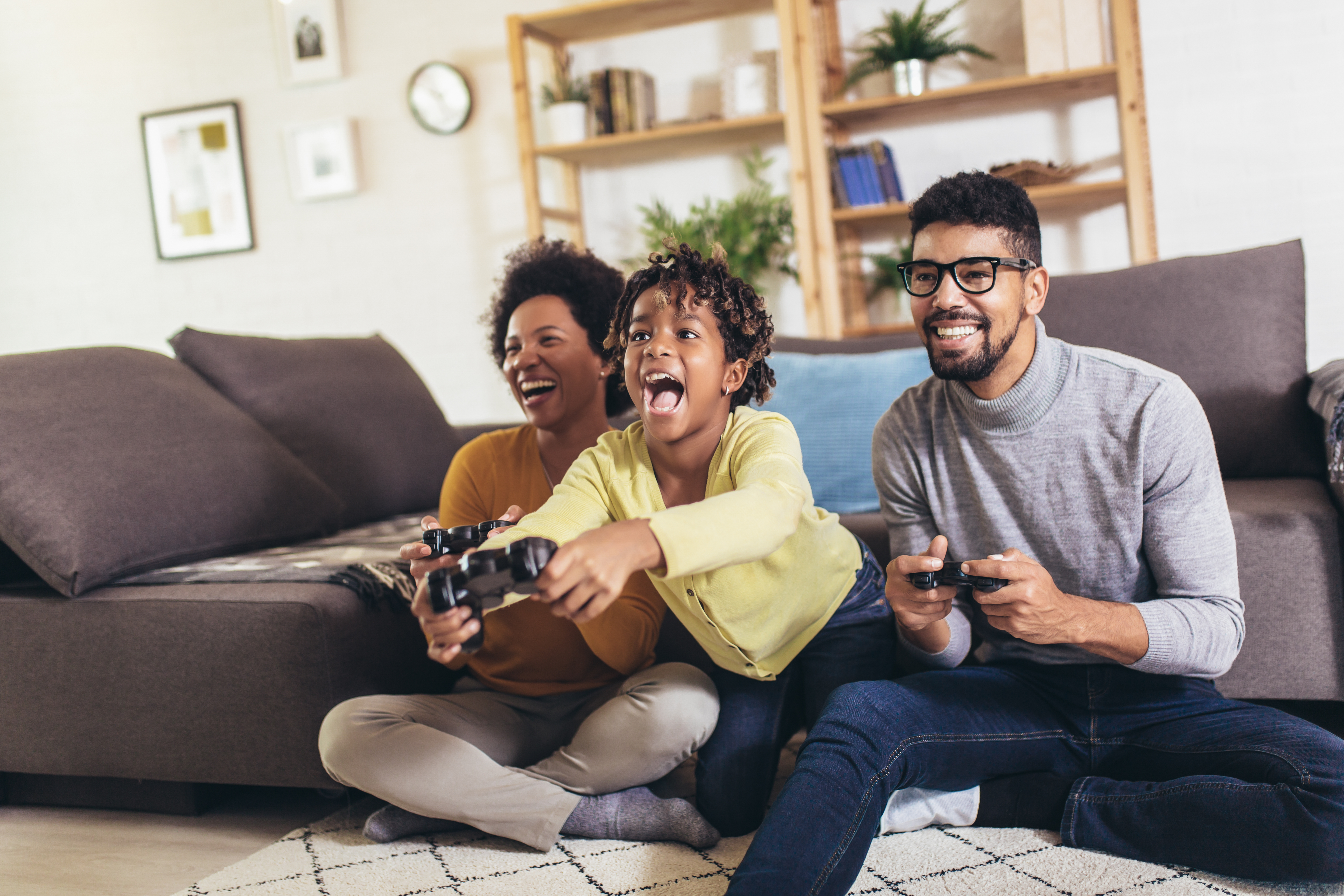 Family sitting on the floor playing video games together