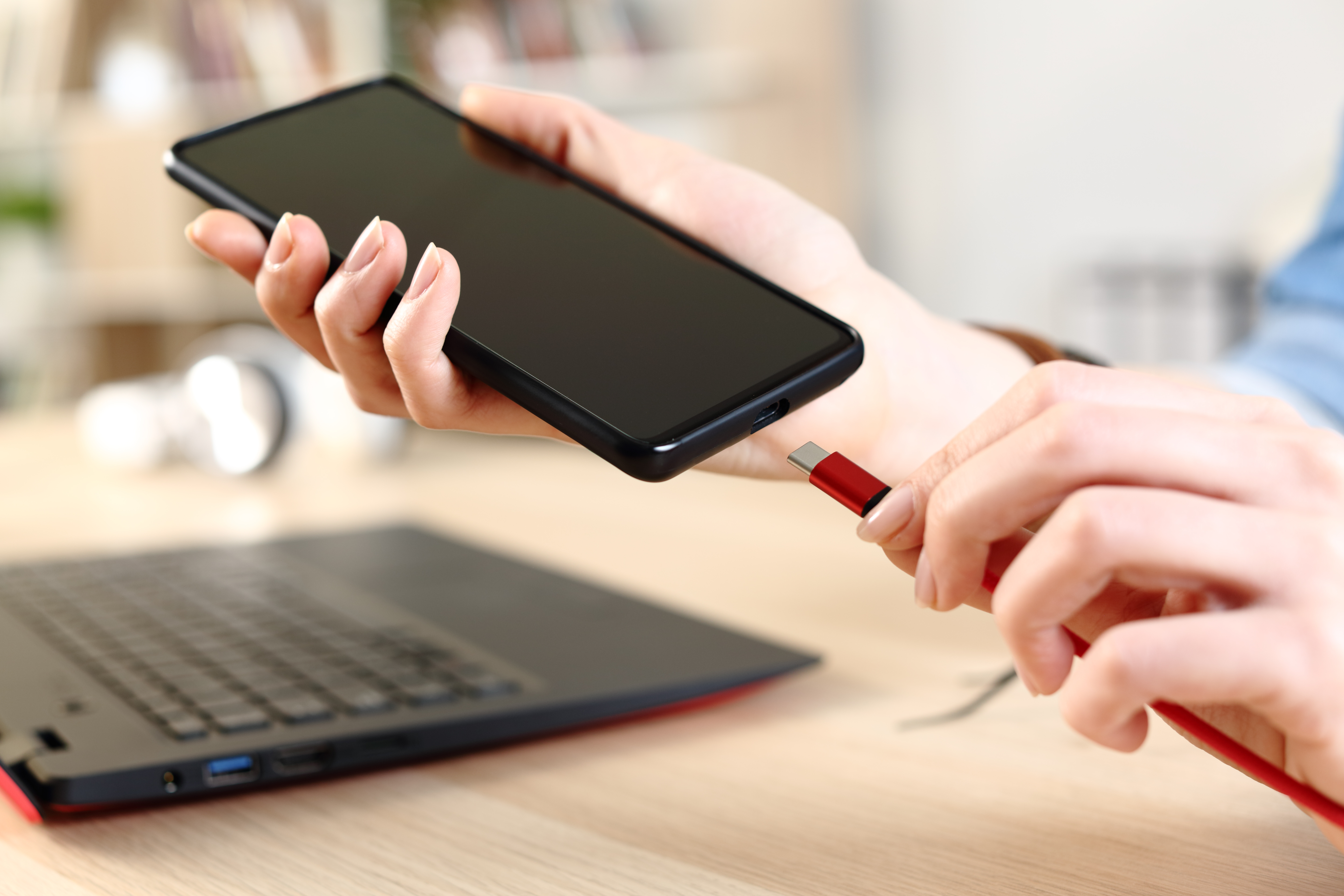 Person plugging their smartphone into a charger