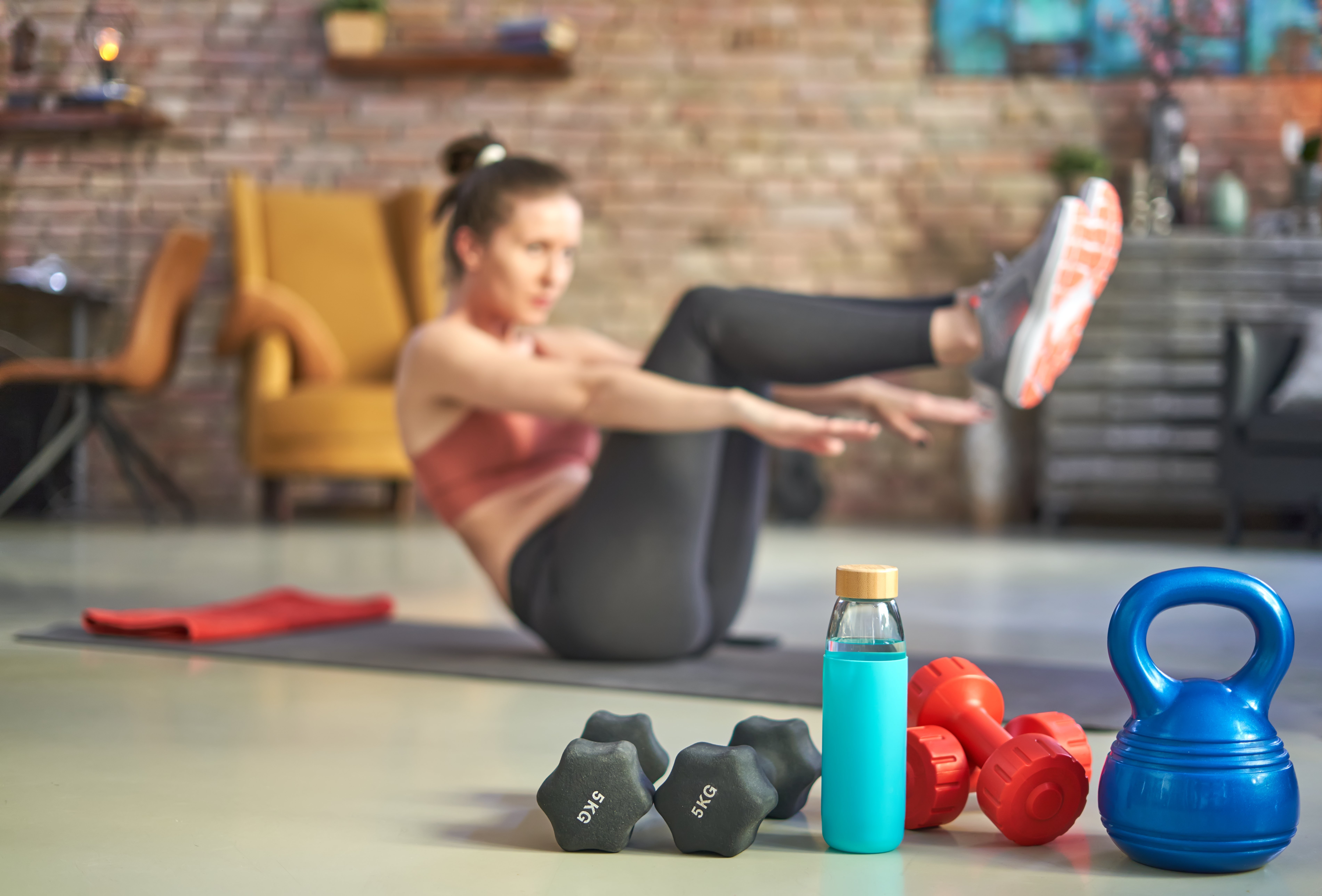 Woman exercising next to free weights