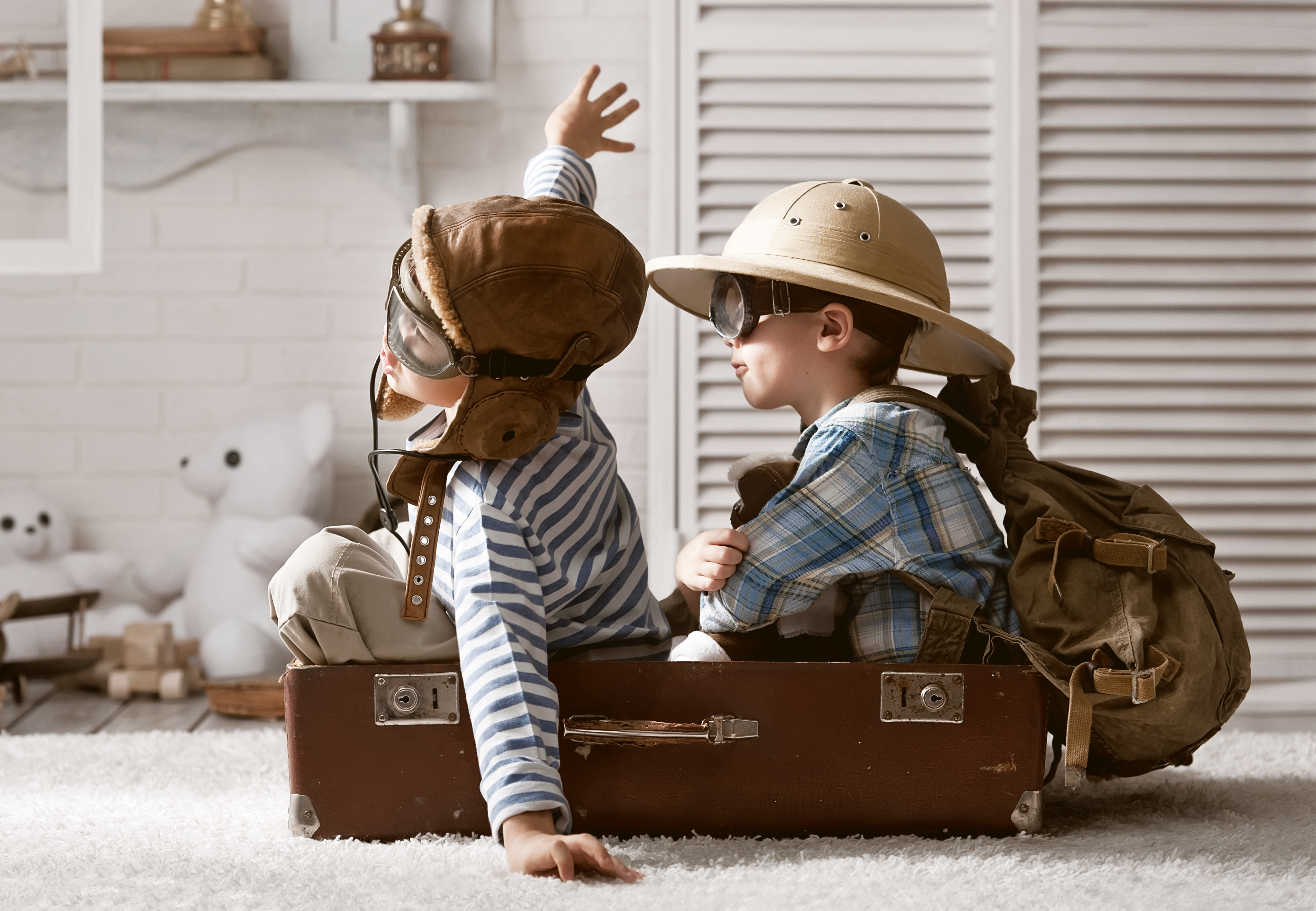two boys piloting a suitcase