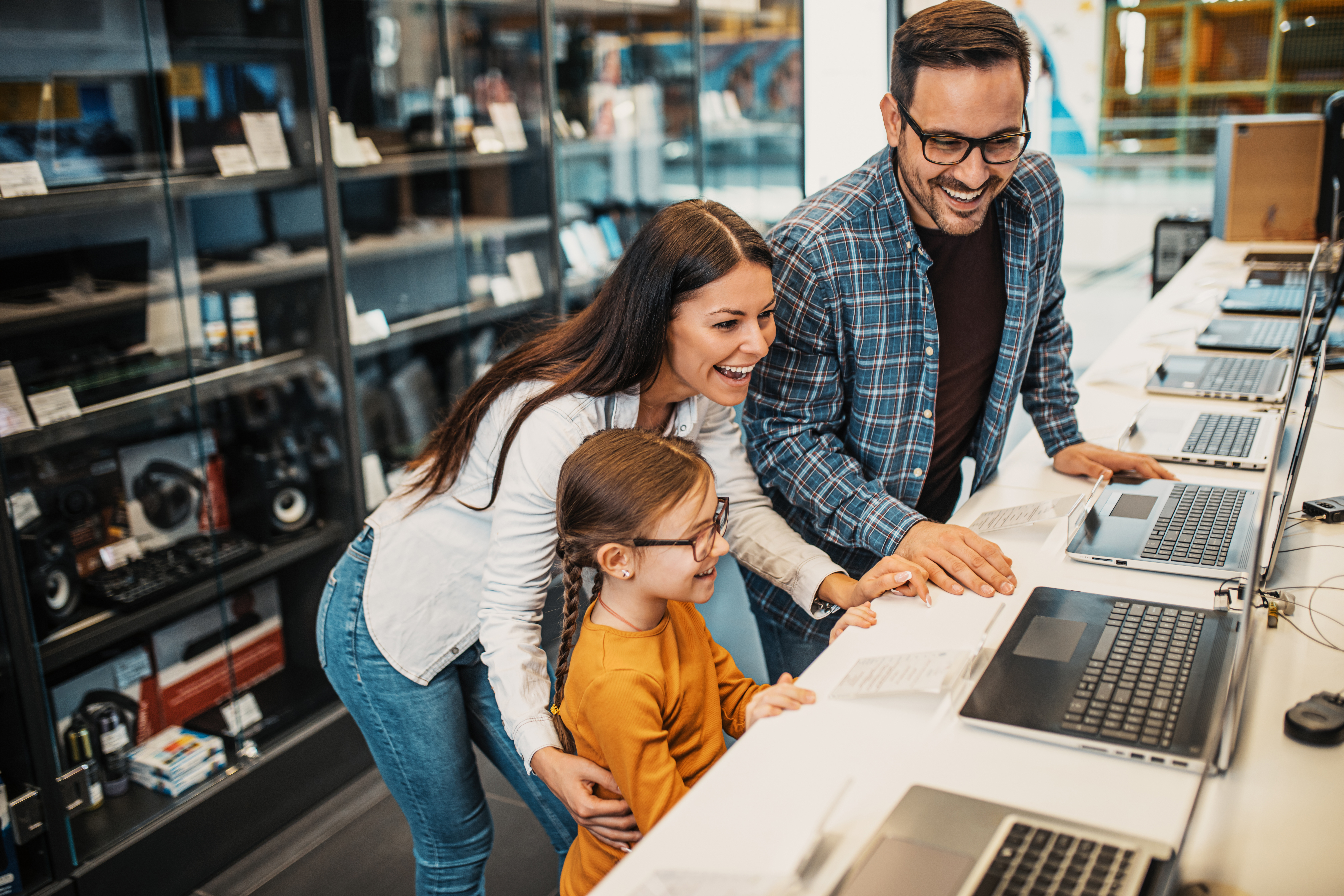 Family smiling and shopping for laptops