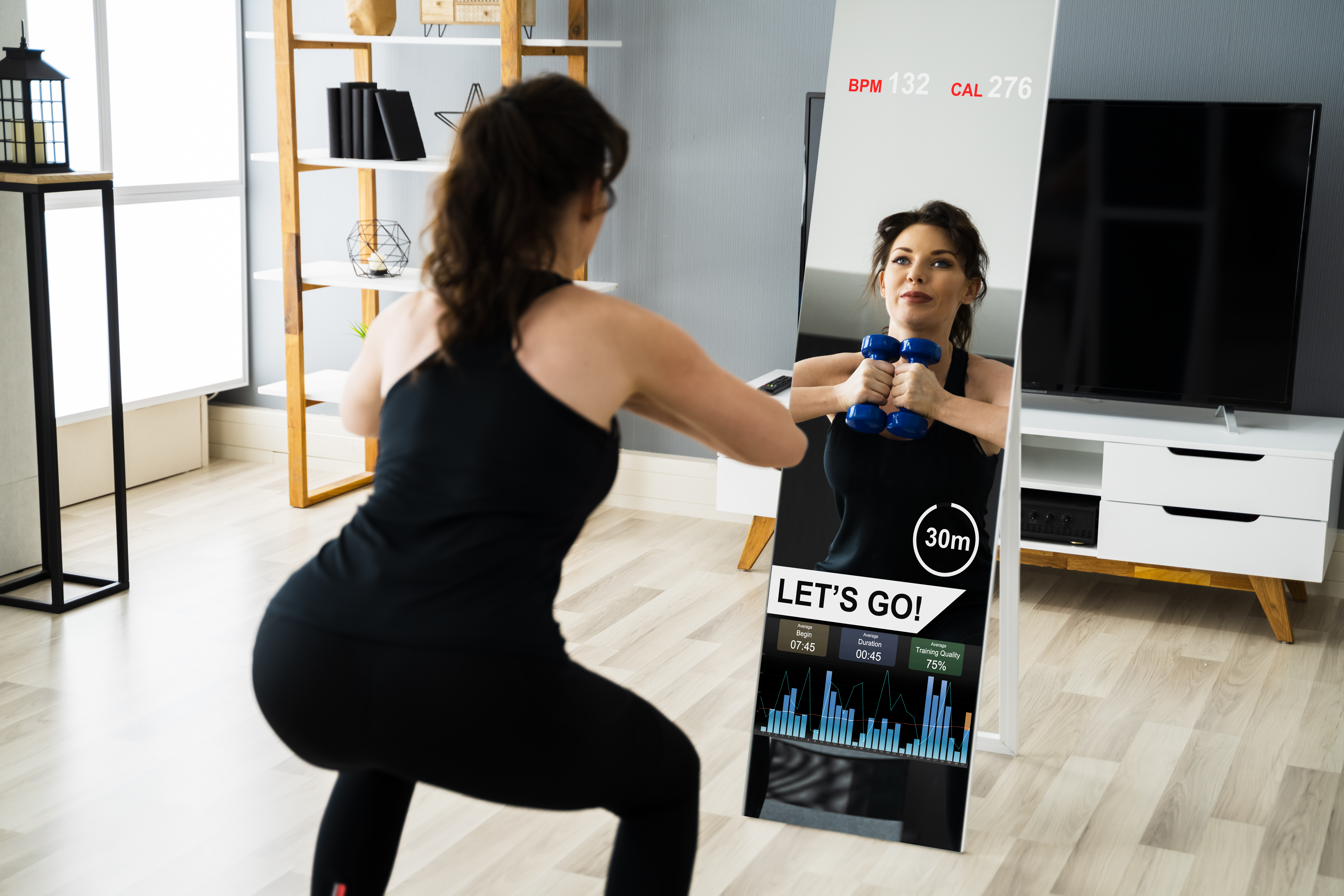 Woman exercising with weights in front of a workout mirror