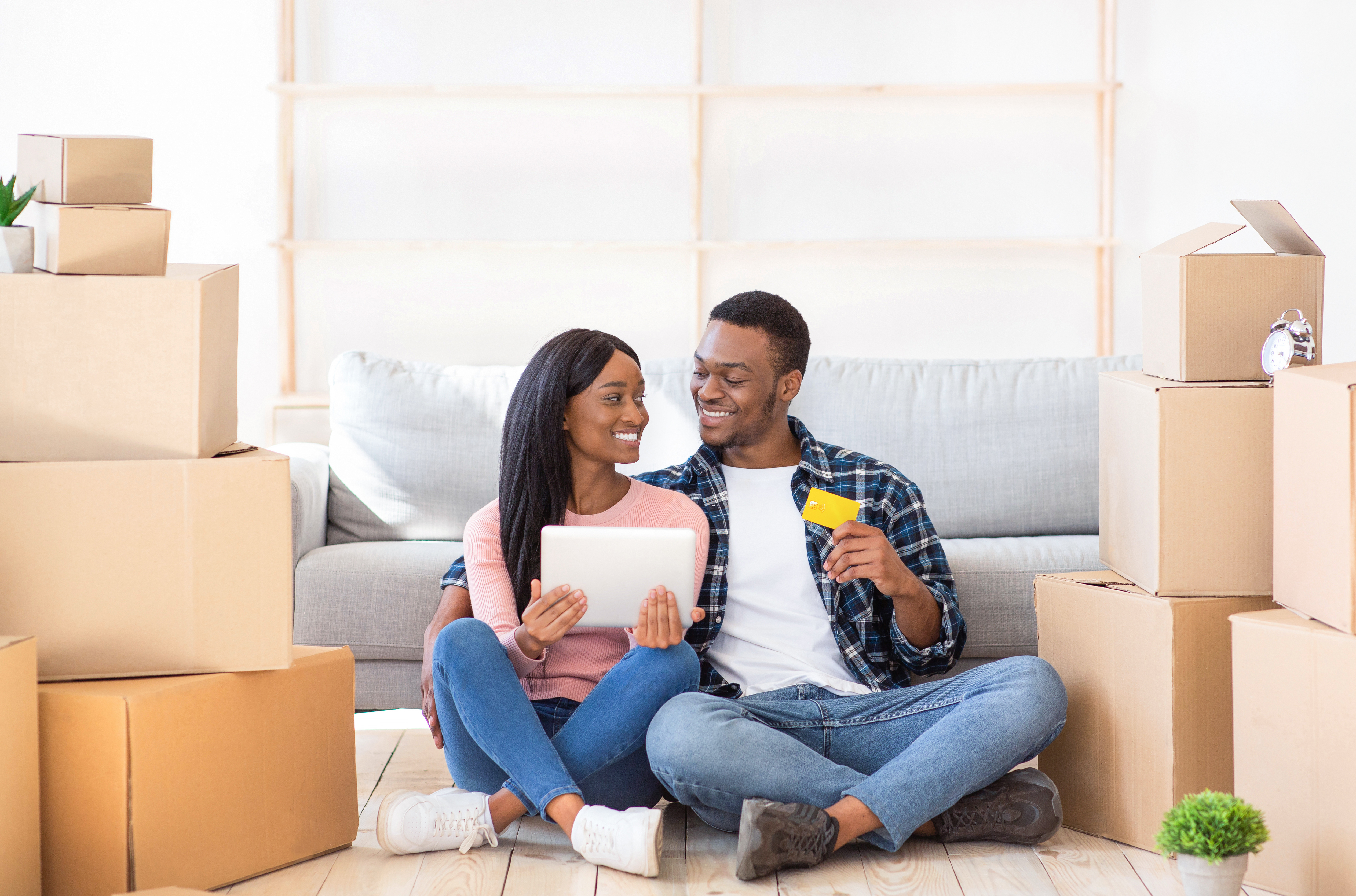 Man and woman sitting on the floor surrounded by boxes