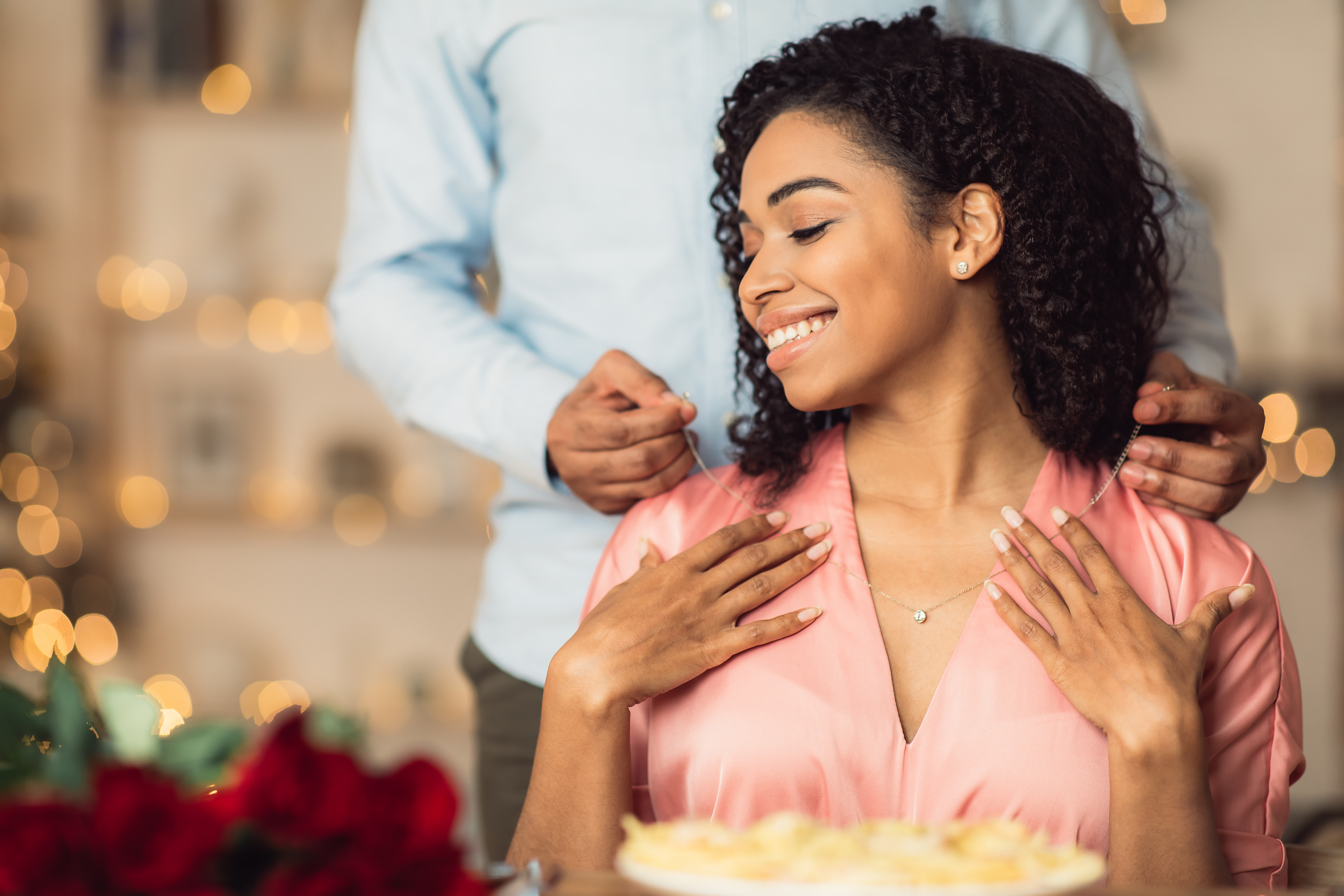 Man putting necklace on woman