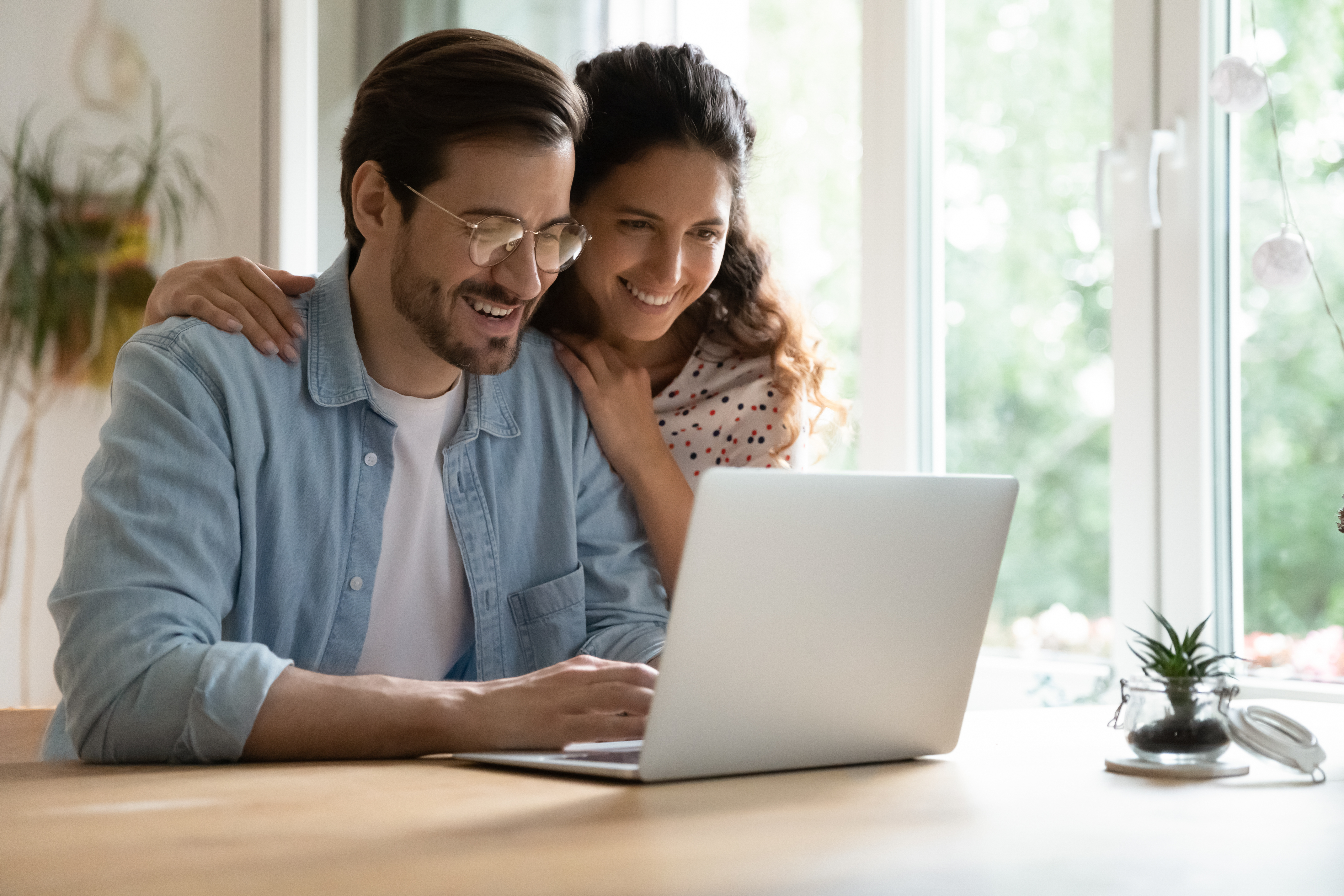 Couple smiling looking at a laptop together