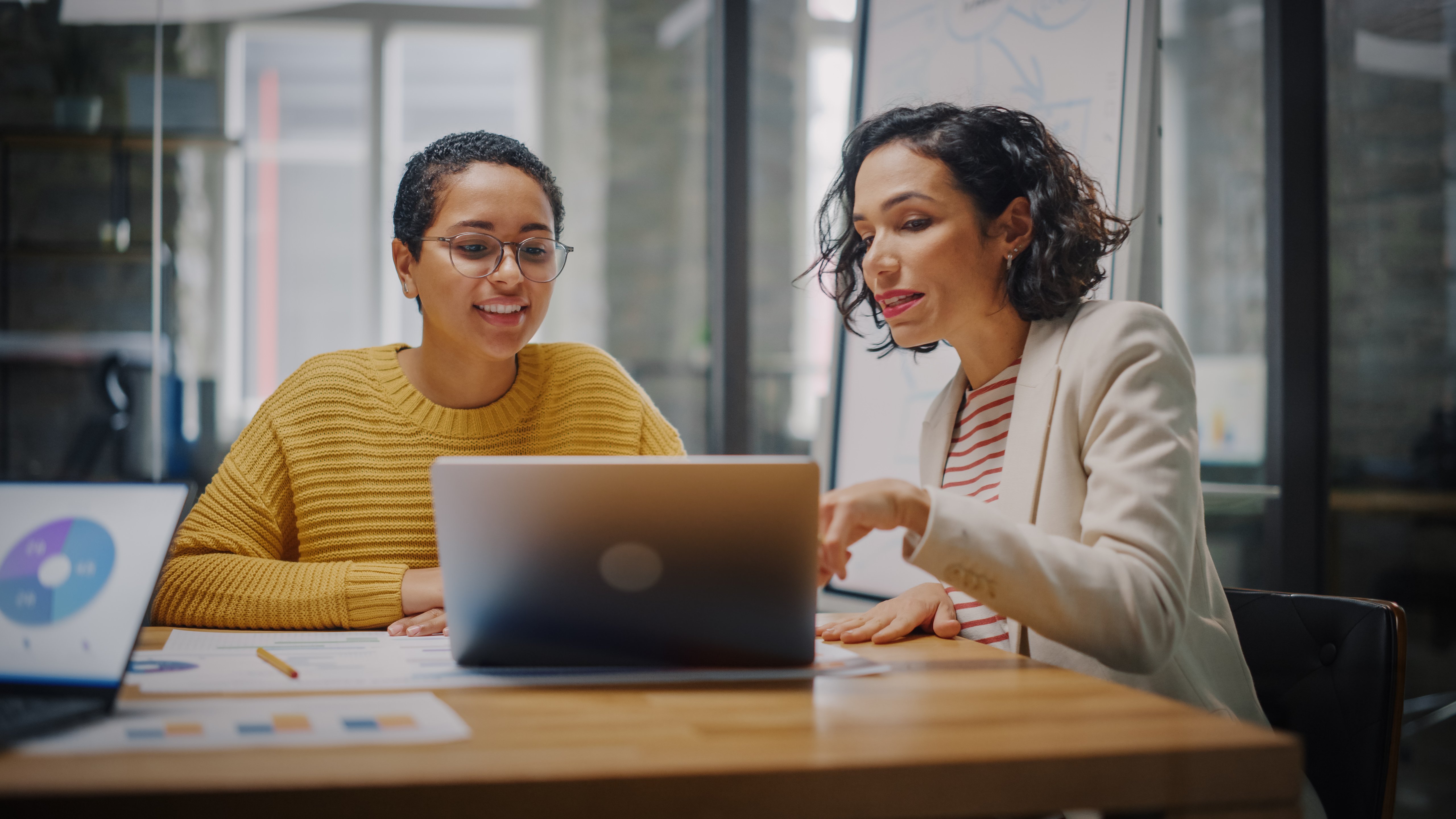 Two women looking at a computer having a discussion