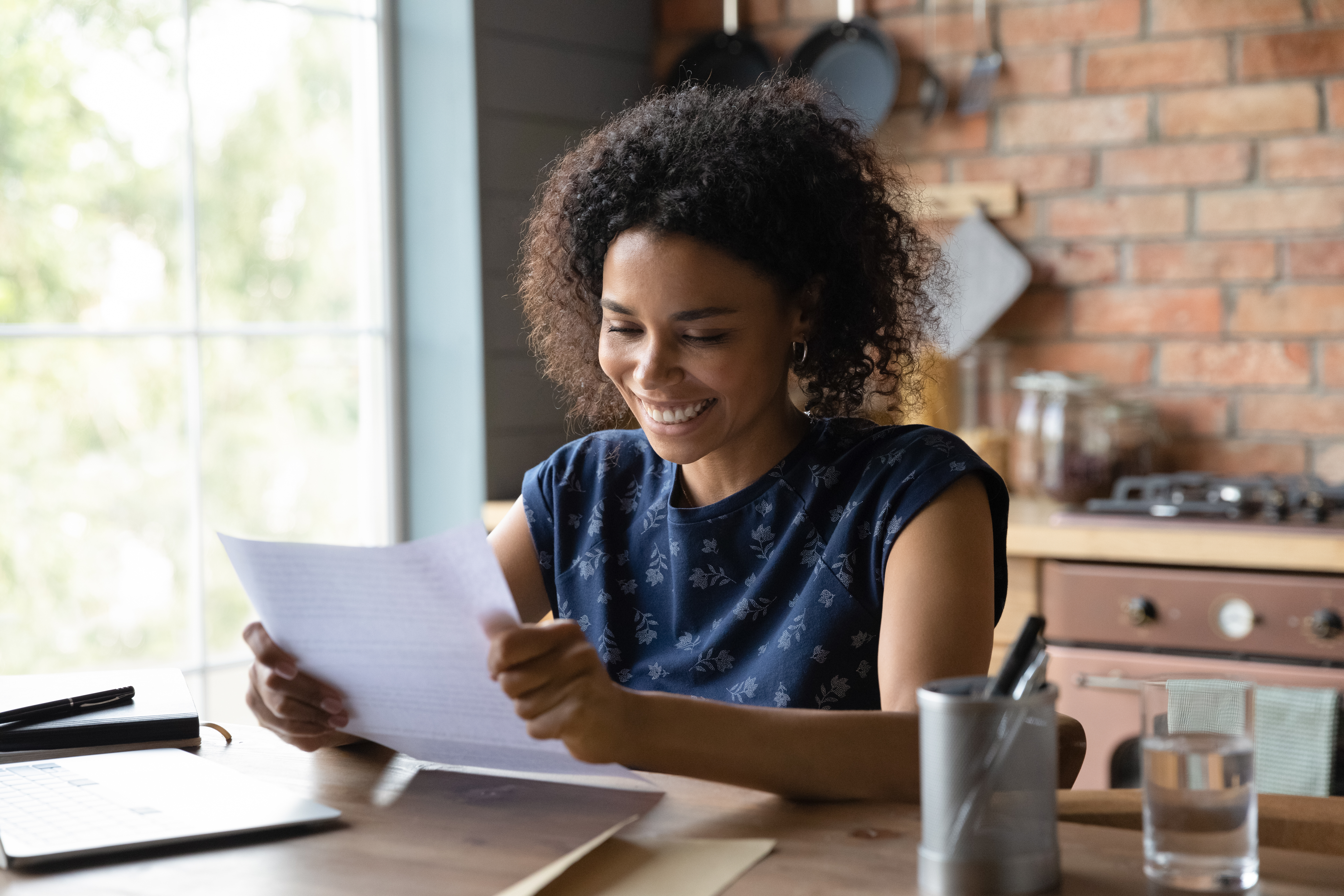 Woman holding a piece of paper and smiling