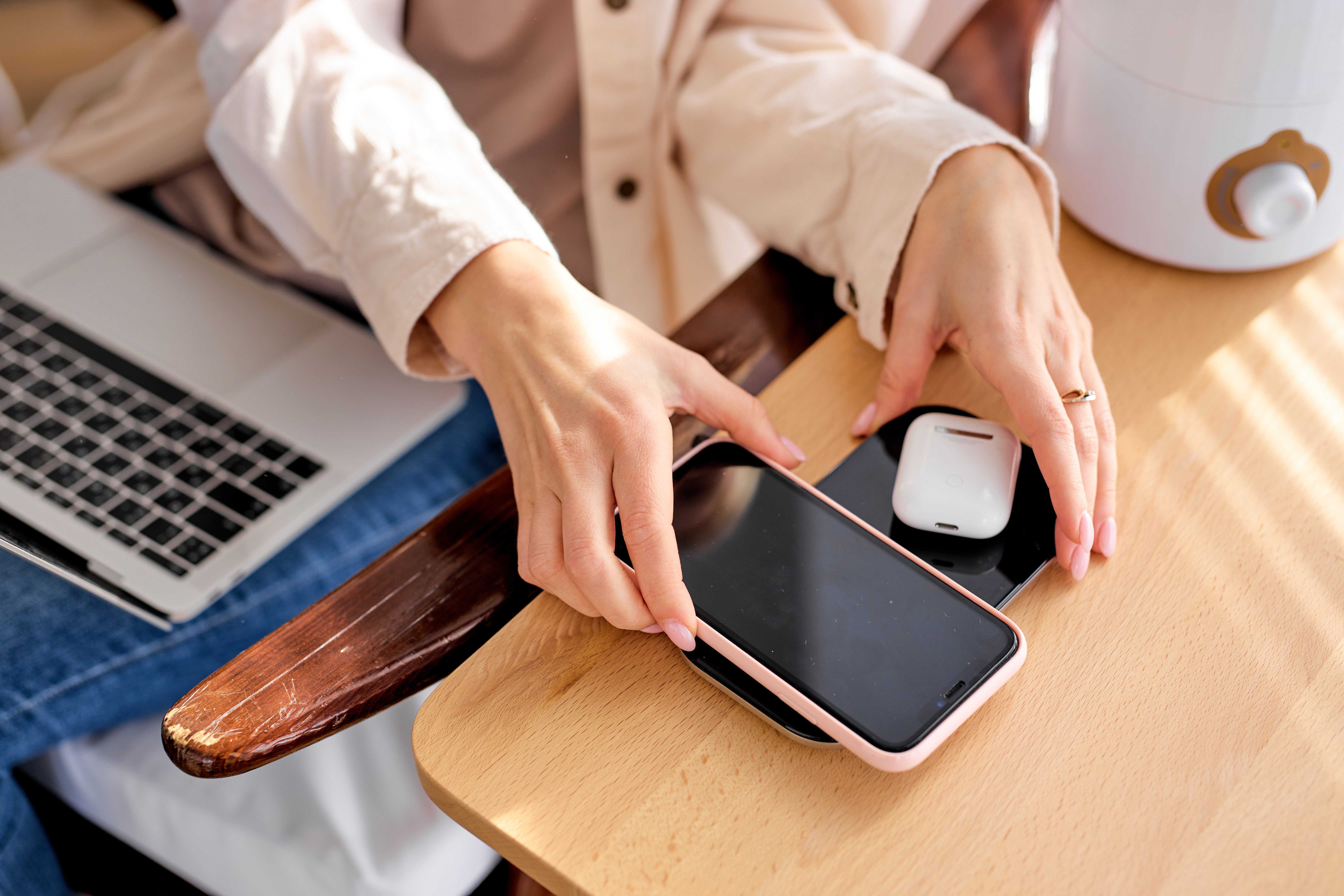 Woman putting her iPhone and AirPods on a wireless charger