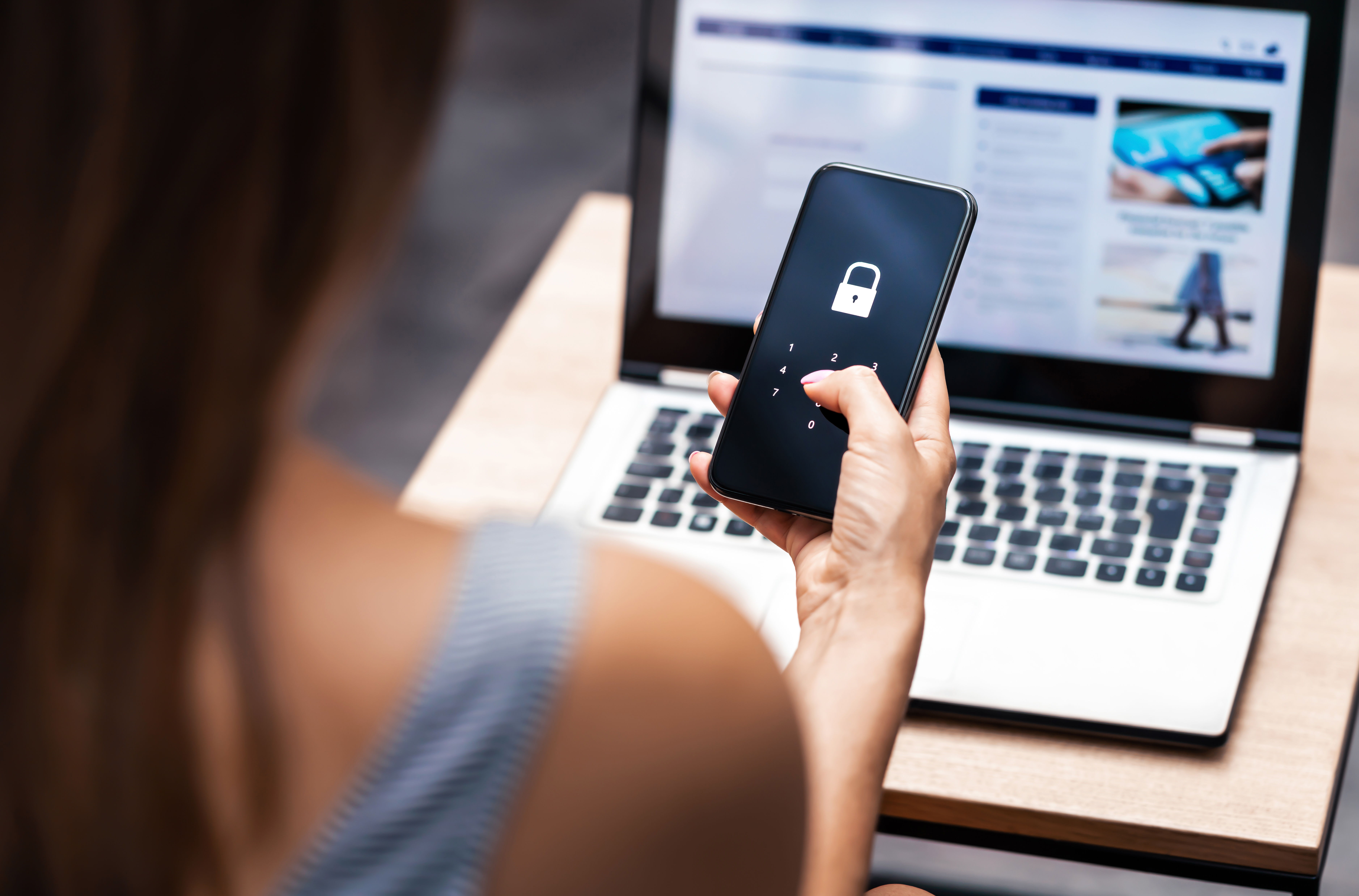 Woman holding a smartphone with an image of a lock on it