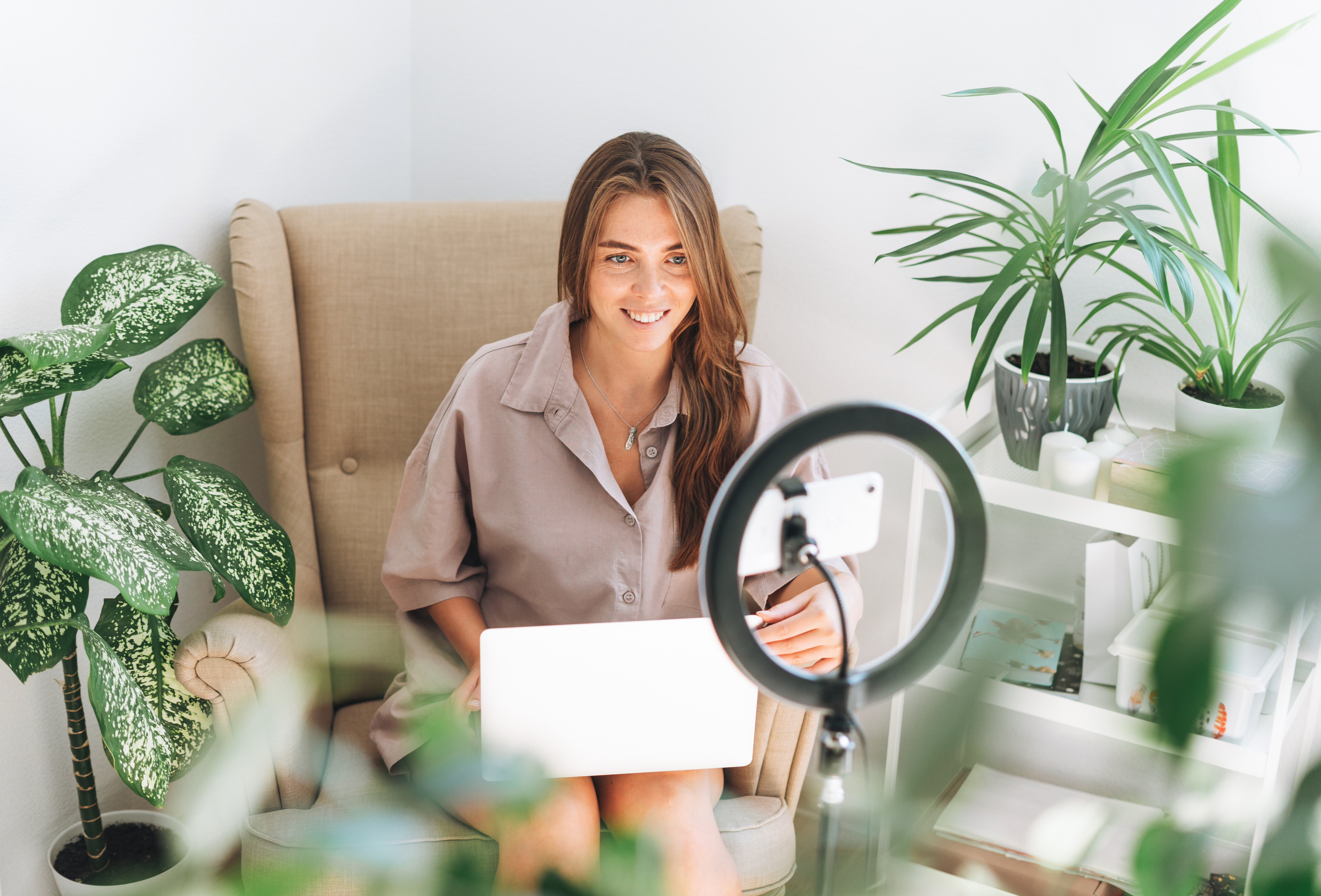 Woman sitting on a chair in front of a ring light