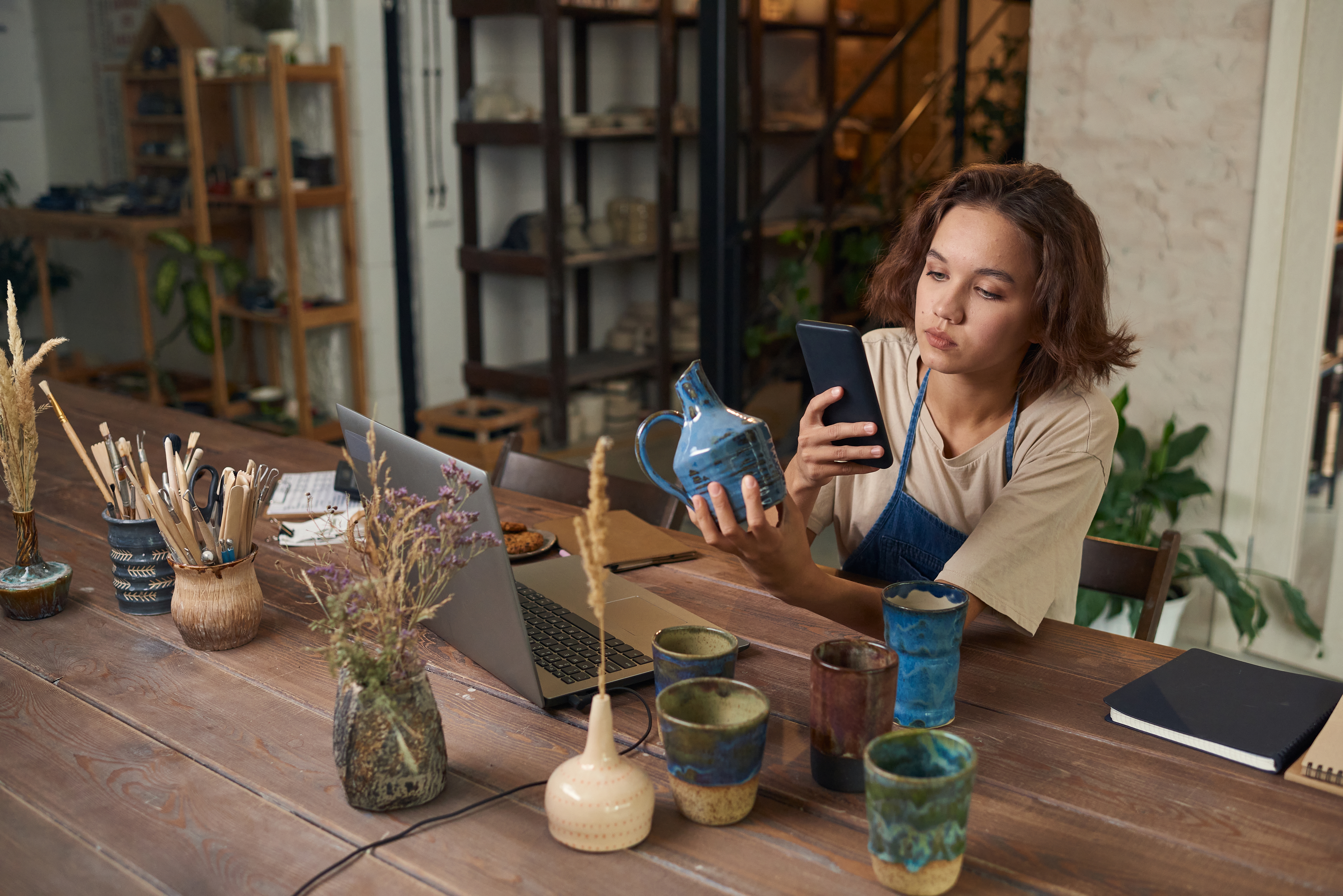 Woman taking a picture of a piece of pottery to sell online