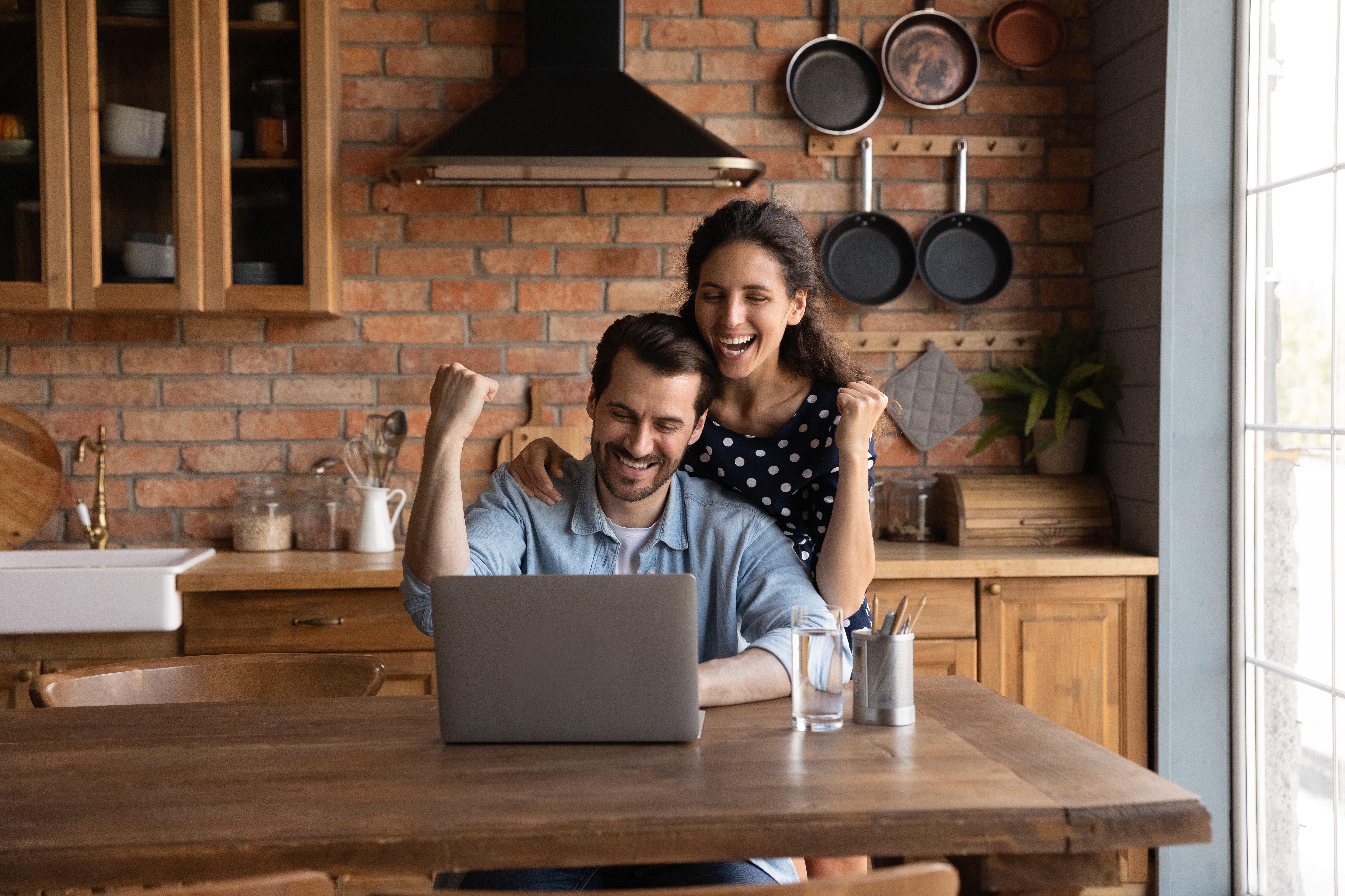 Man and woman excitedly looking at a laptop
