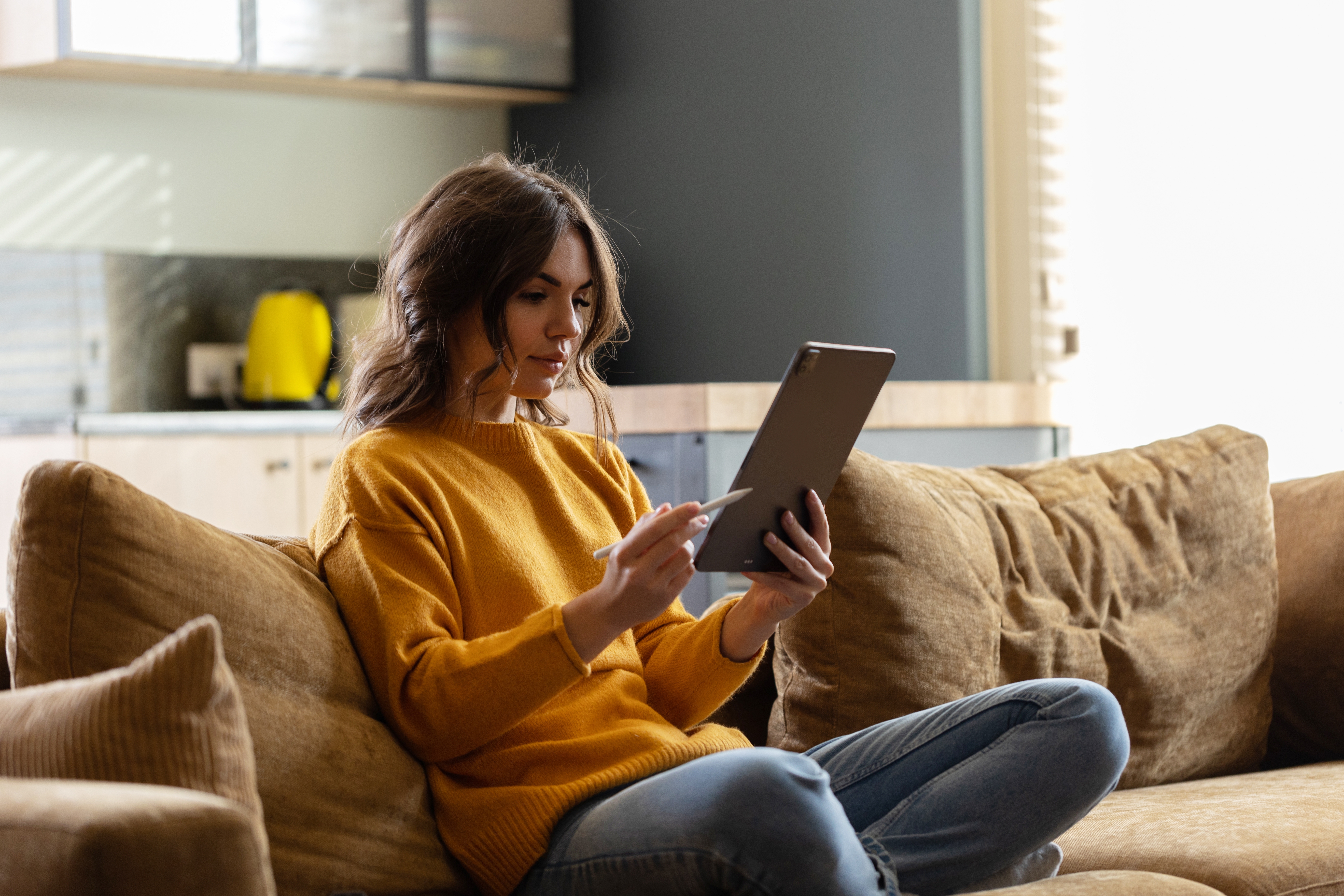 Woman sitting on couch using Apple iPad