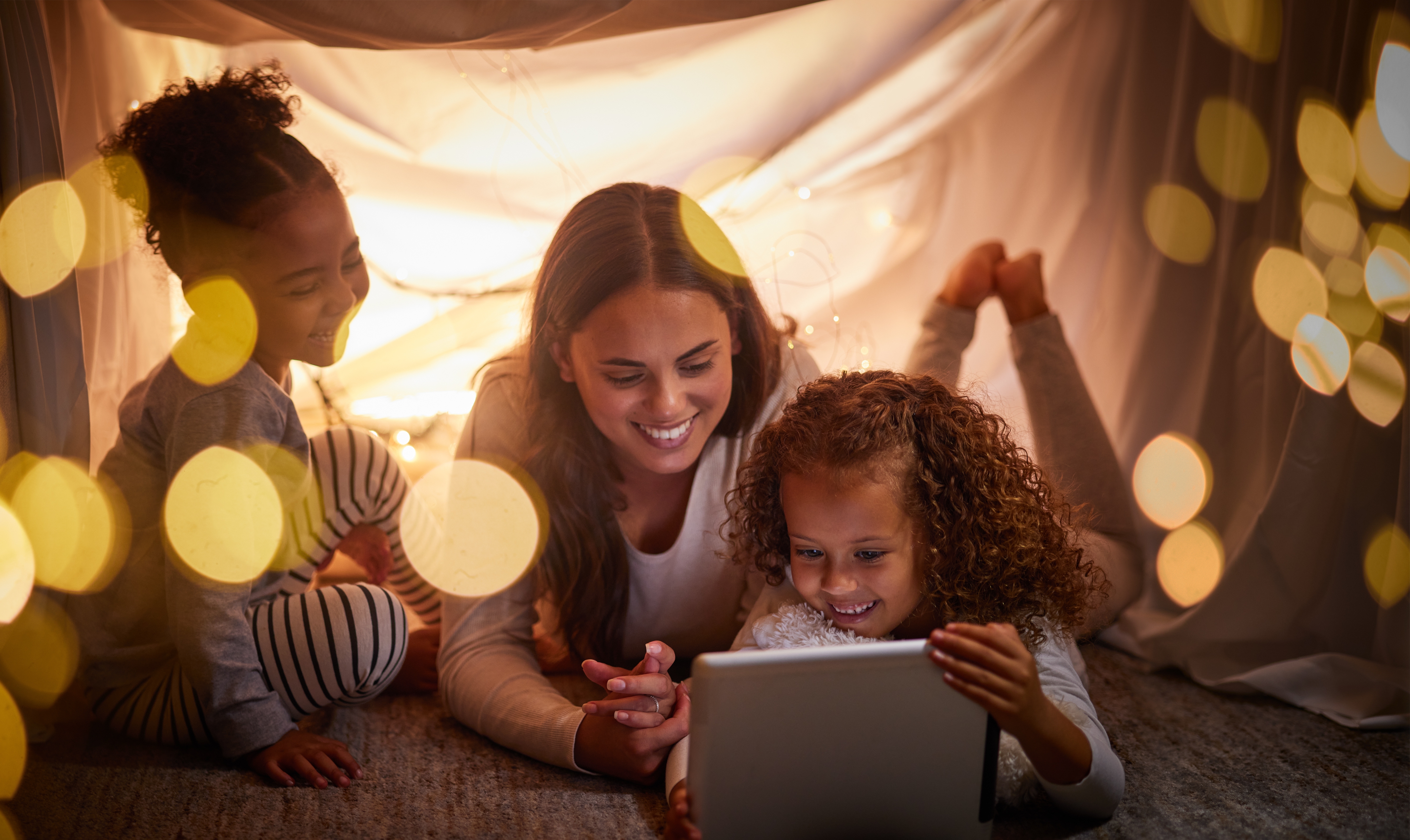 Mom and two daughters watching on a tablet