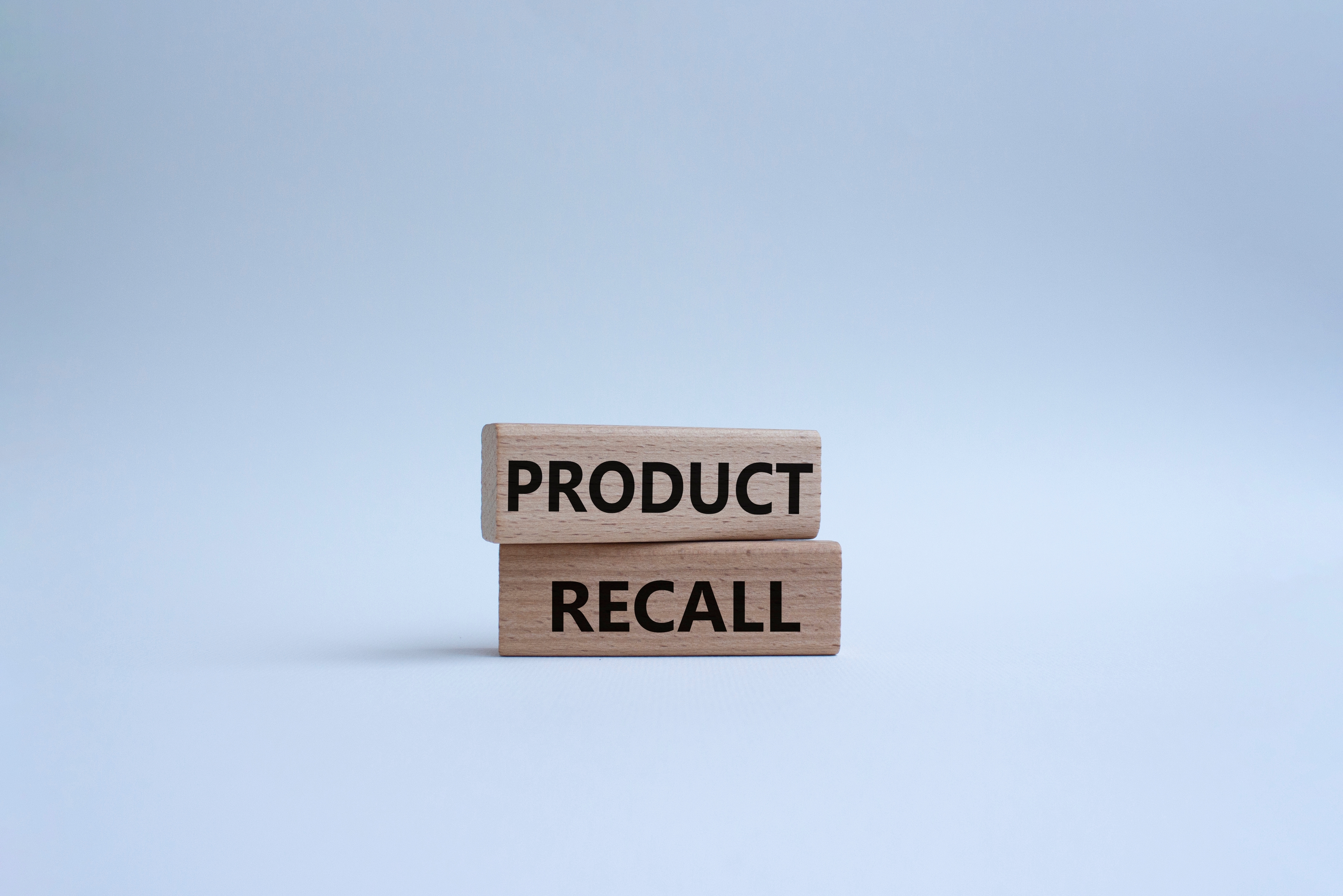 Two wooden blocks with the words product recall on them
