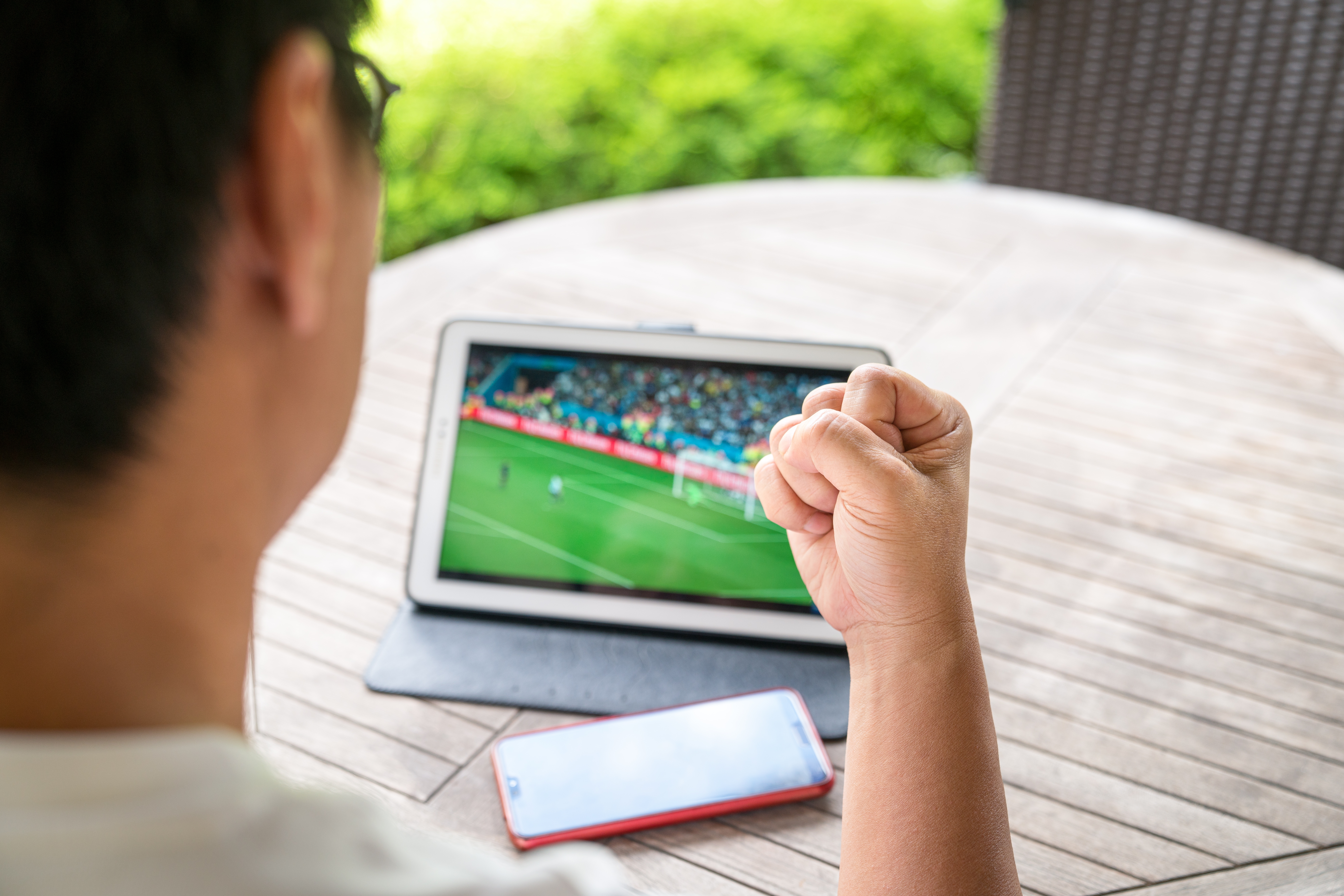 Man watching soccer on a tablet