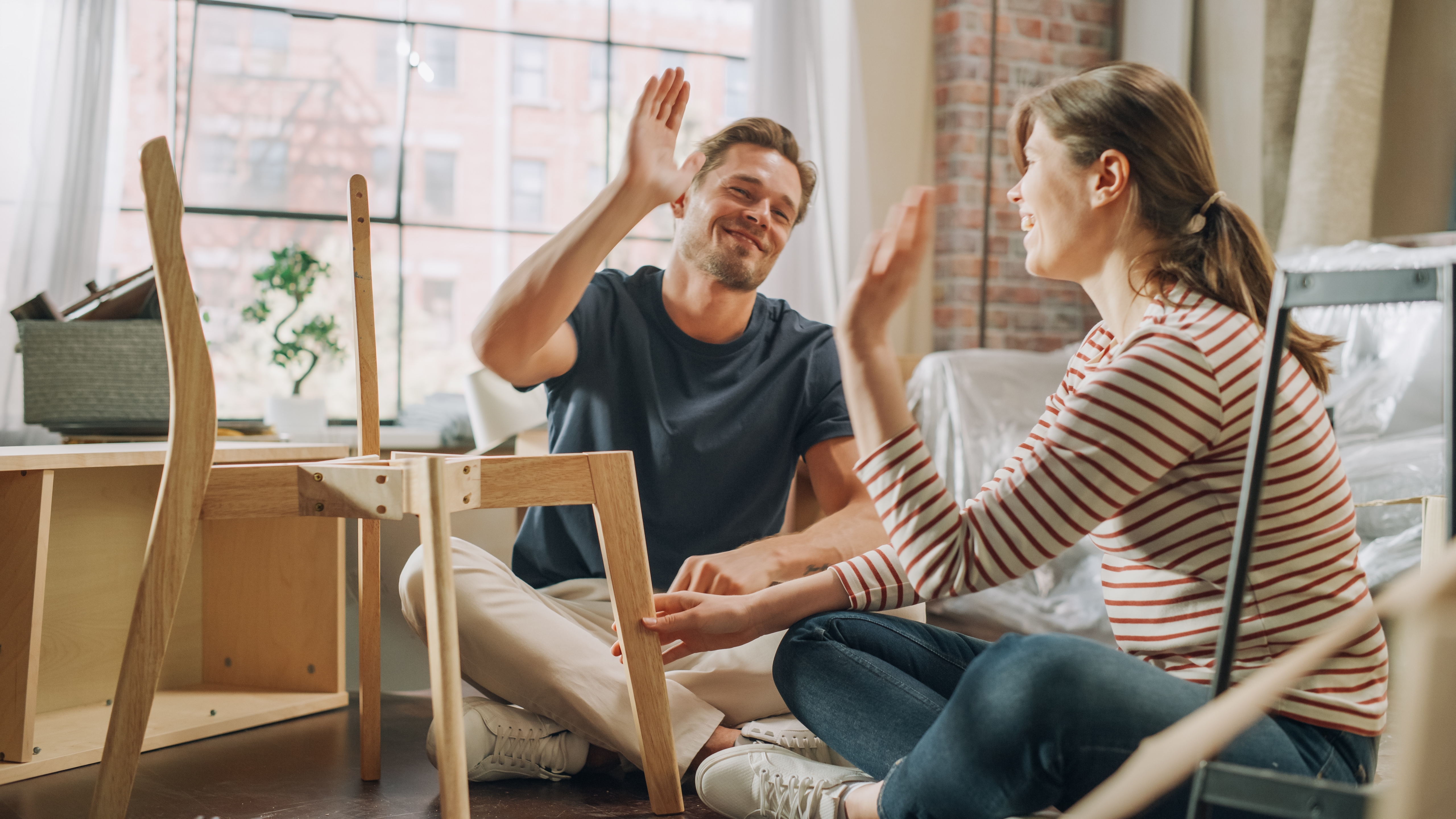 Man and woman building a chair and high-fiving