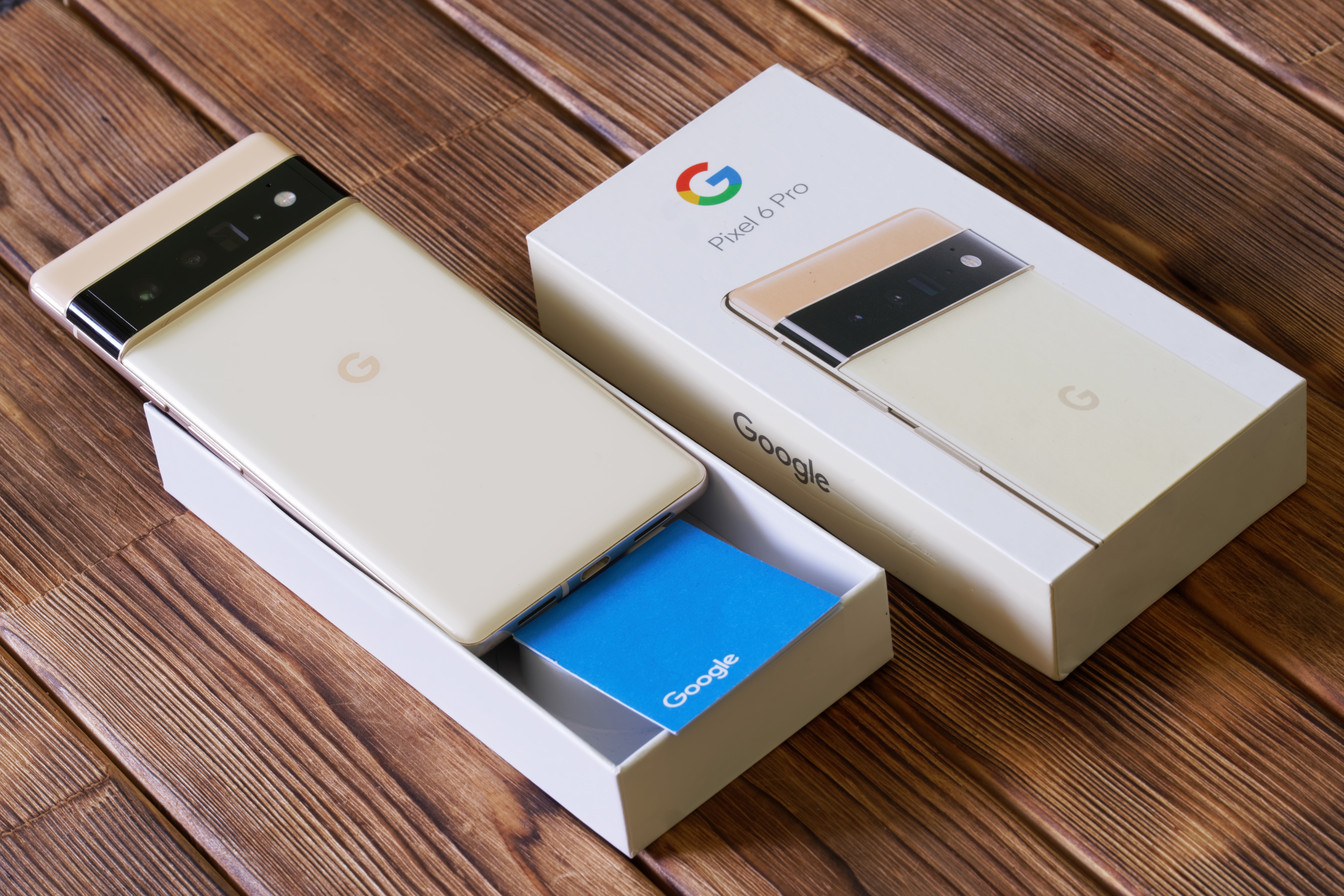 Two Google Pixel 6 phones on a wood table